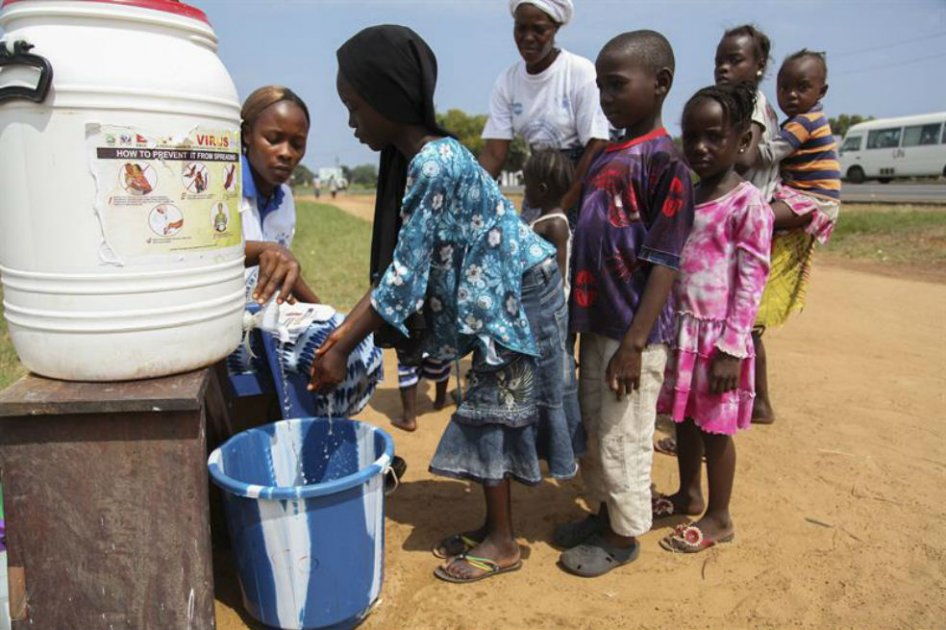 Niños liberianos son asistidos en el lavado de manos como parte de un programa de sensibilización para evitar el contagio del ébola