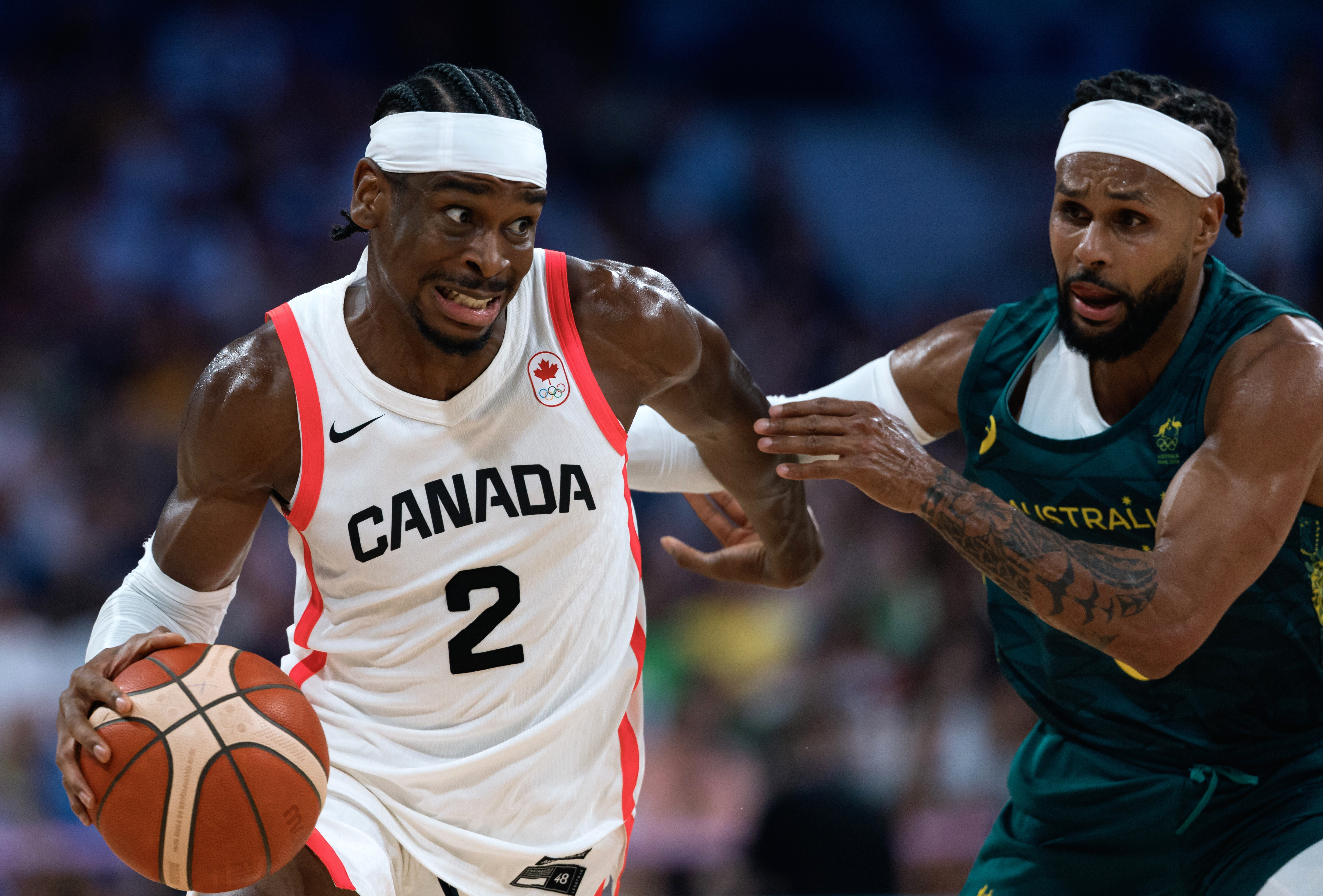 Villeneuve-d'ascq (France), 30/07/2024.- Shai Gilgeous-Alexander of Canada (L) in action against Patty Mills of Australia (R) during the Men's Group A match between Australia and Canada in the Paris 2024 Olympic Games, at the Pierre Mauroy Stadium in Villeneuve-d'Ascq, France, 30 July 2024. (Baloncesto, Francia) EFE/EPA/ALEX PLAVEVSKI
