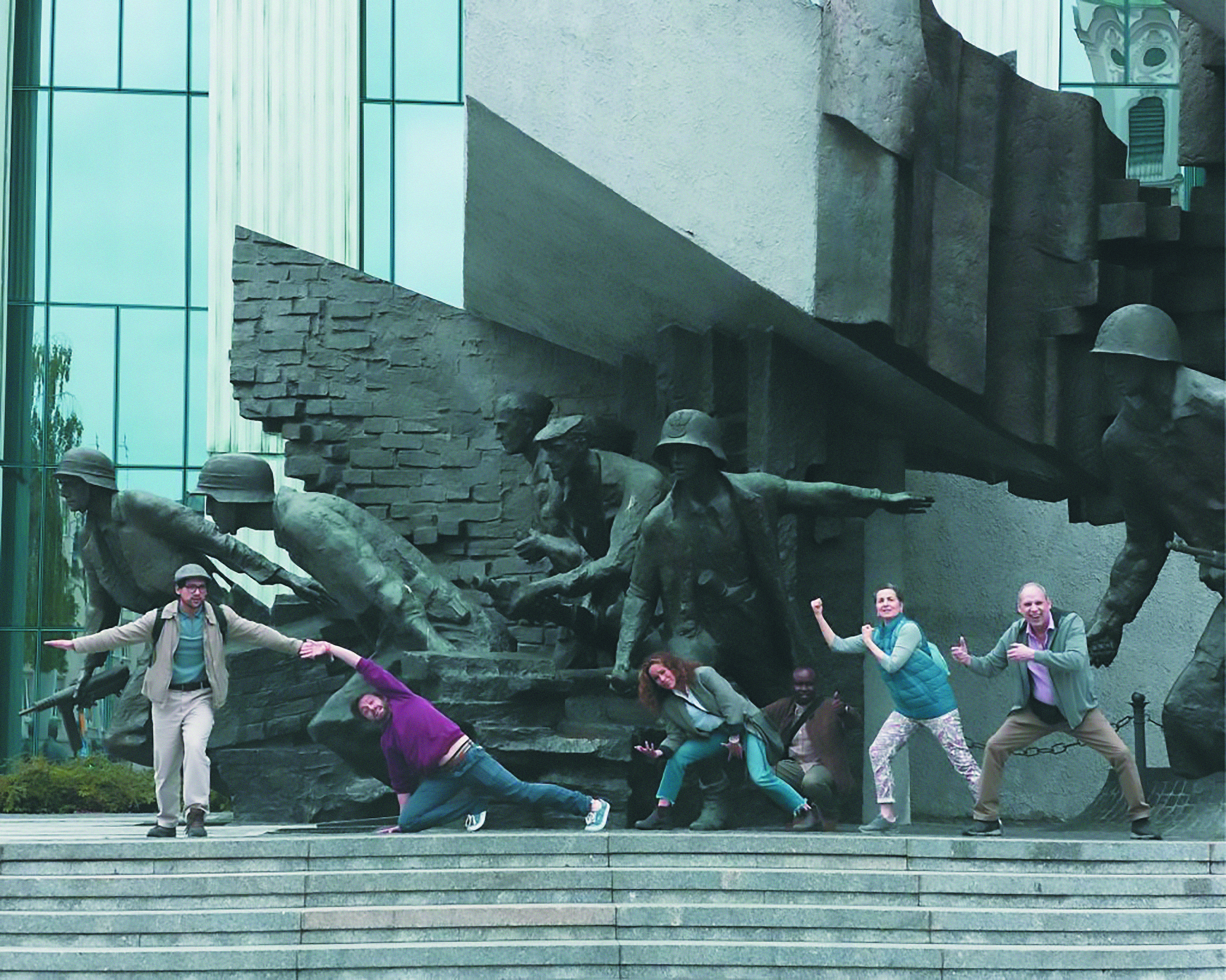 En la imagen, los personajes de la película juegan a ser parte del grupo de soldados del Monumento al Alzamiento de Varsovia.