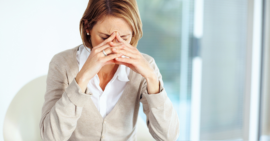 Portrait of mature disappointed businesswoman sitting at desk in office