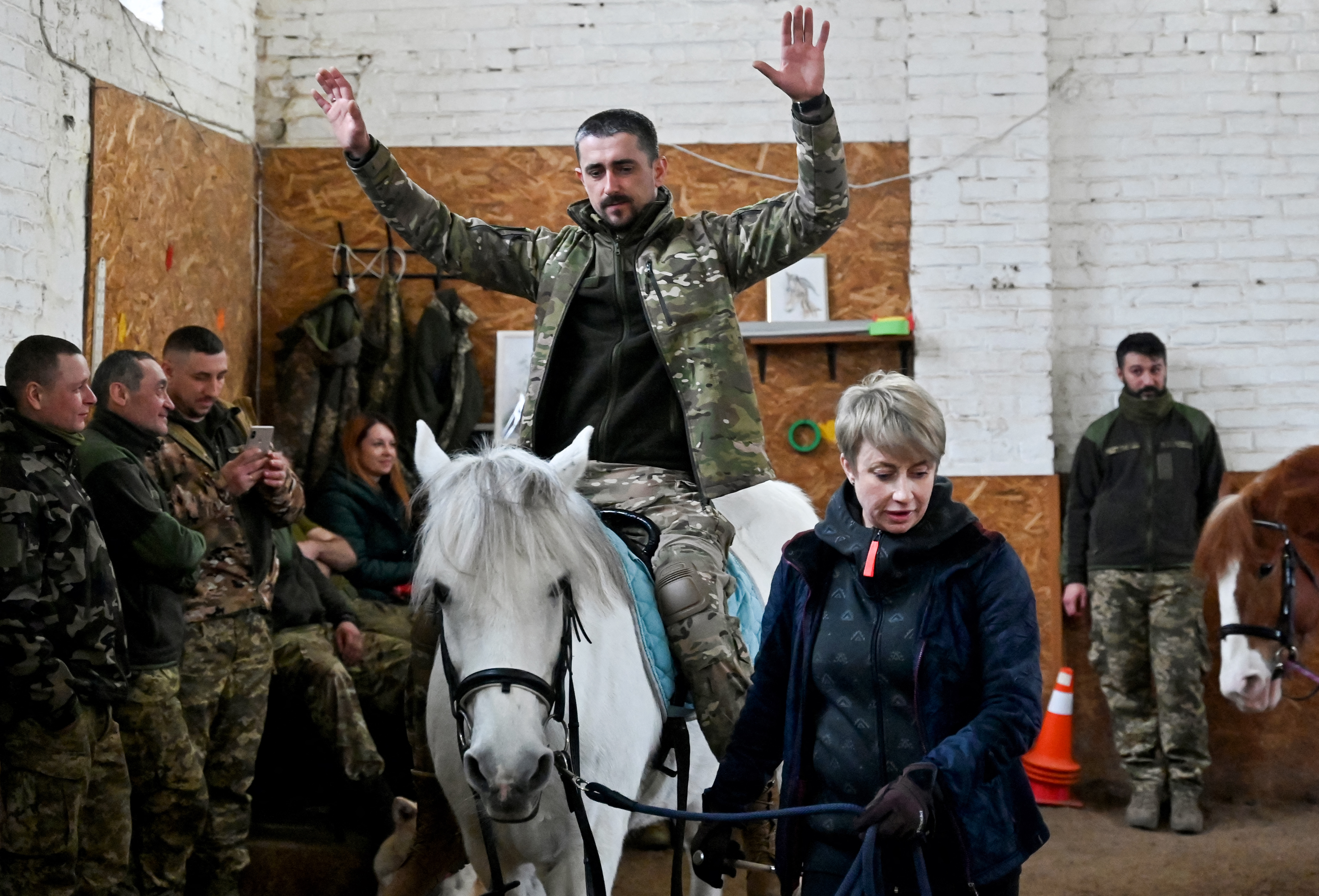 Un jinete en uniforme de camuflaje monta a Melocotón, uno de los caballos de un centro ecuestre de las afueras de Kiev donde los soldados ucranianos descansan de los horrores de la guerra.