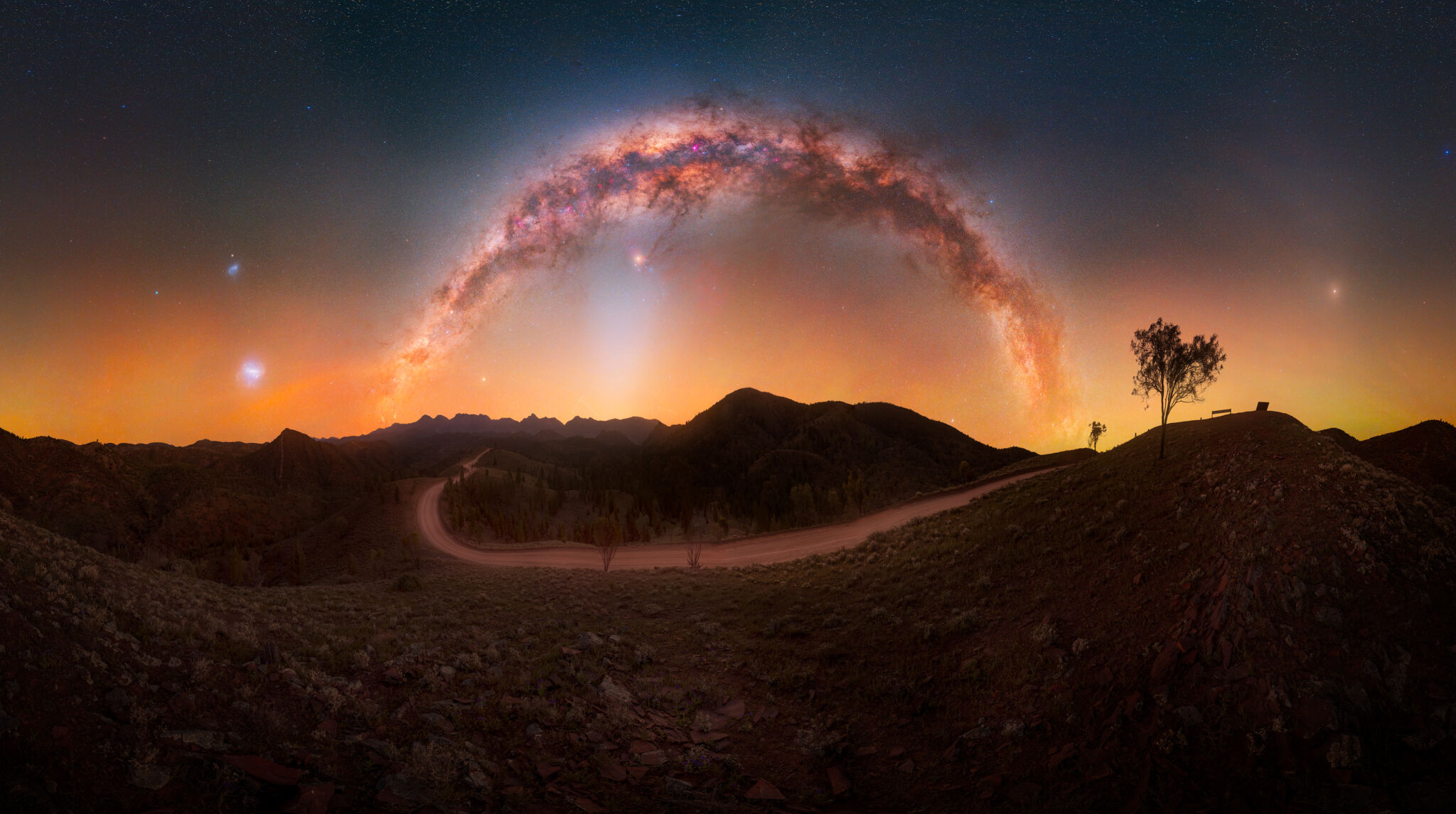 «Tomada desde el mirador de Razorback, en la cordillera de Flinders, en Australia Meridional, esta panorámica abarca todo el cielo nocturno del sur. La Vía Láctea se arquea sobre nuestras cabezas, mientras que las Nubes de Magallanes, la Grande y la Pequeña, se alzan al sur y la luz zodiacal surge por el este, todo ello visible en una sola noche de invierno. Esta imagen rinde homenaje a la extraordinaria claridad de los cielos oscuros de Australia, donde se pueden contemplar múltiples fenómenos celestes a la vez sobre un emblemático paisaje del interior».