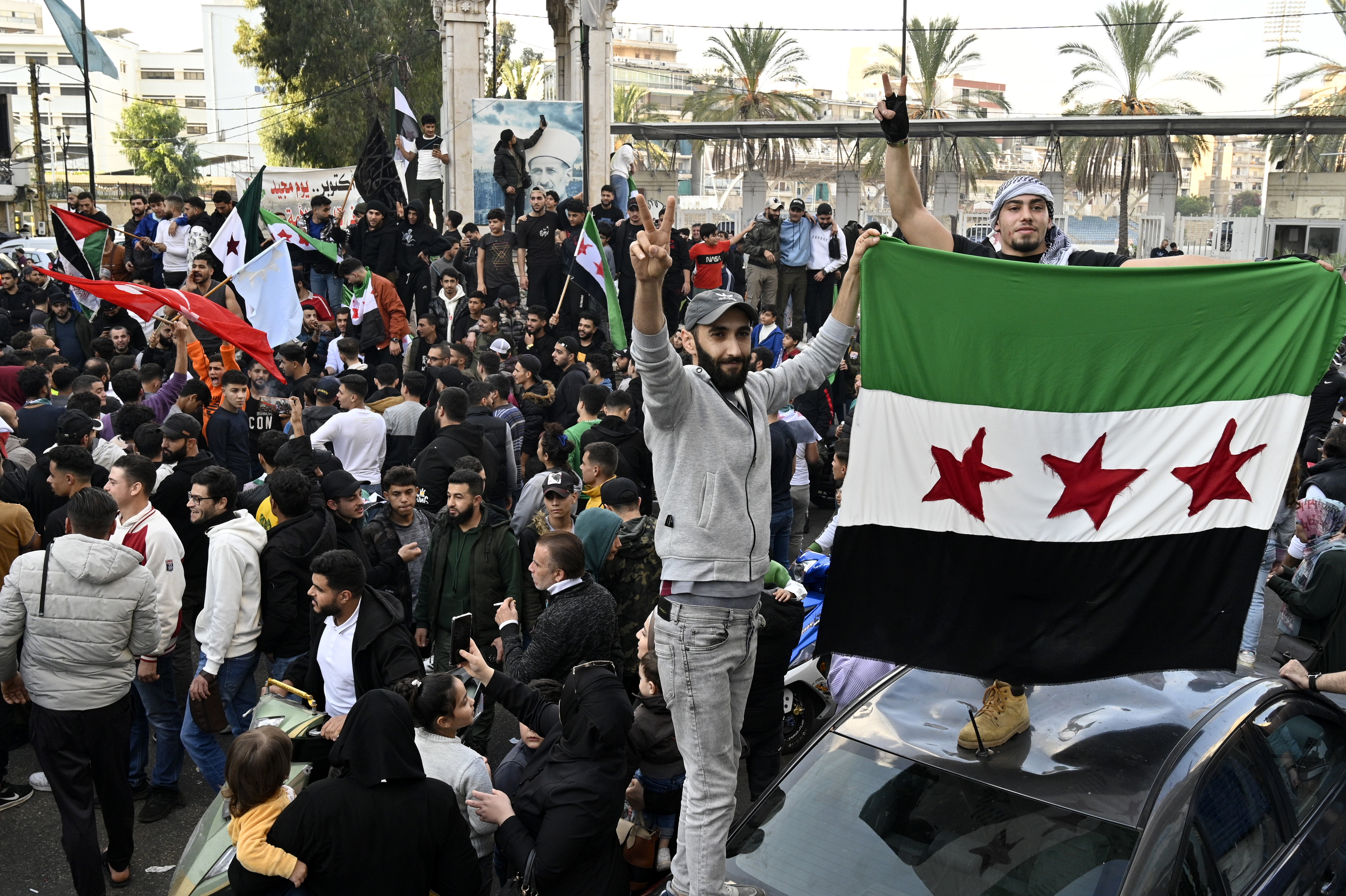 Beirut (Lebanon), 08/12/2024.- Two men hold the Syrian opposition flag as Lebanese and Syrian people gather to celebrate the rebel takeover of Damascus, in Beirut, Lebanon, 08 December 2024. Syrian rebels entered Damascus on 08 December 2024 and announced in a televised statement the 'Liberation of the city of Damascus and the overthrow of Bashar al-Assad', as well as the release of all the prisoners. The rebels also urged the Syrian armed forces to leave Syrian public institutions, which will stay under the control of the outgoing Syrian prime minister until the official handover ceremony. (Líbano, Siria, Damasco) EFE/EPA/WAEL HAMZEH