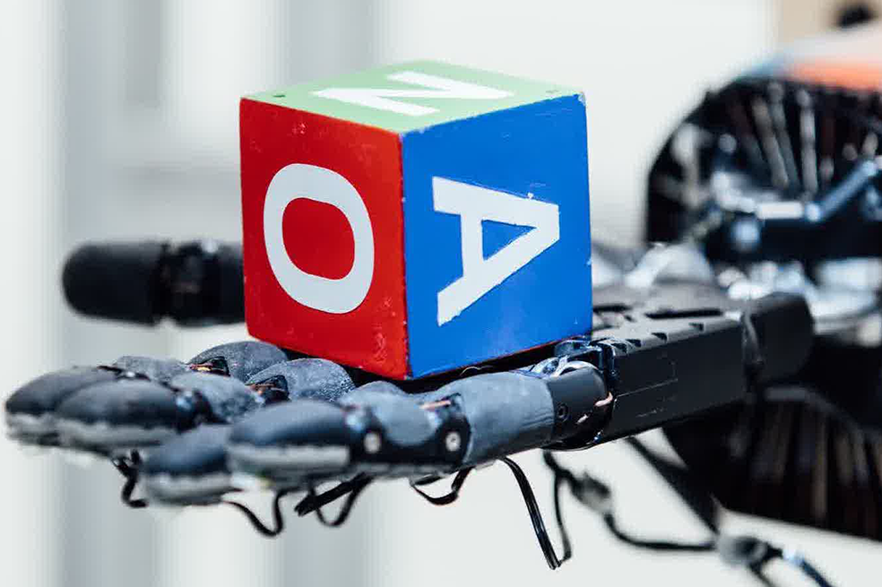 La capacitación directa en robots físicos permite que el programa virtual del robot aprenda de la física del mundo real, pero los algoritmos de hoy requerirían años de experiencia para resolver un problema como la reorientación de objetos. El Dactyl resolvió el problema. / Open AI