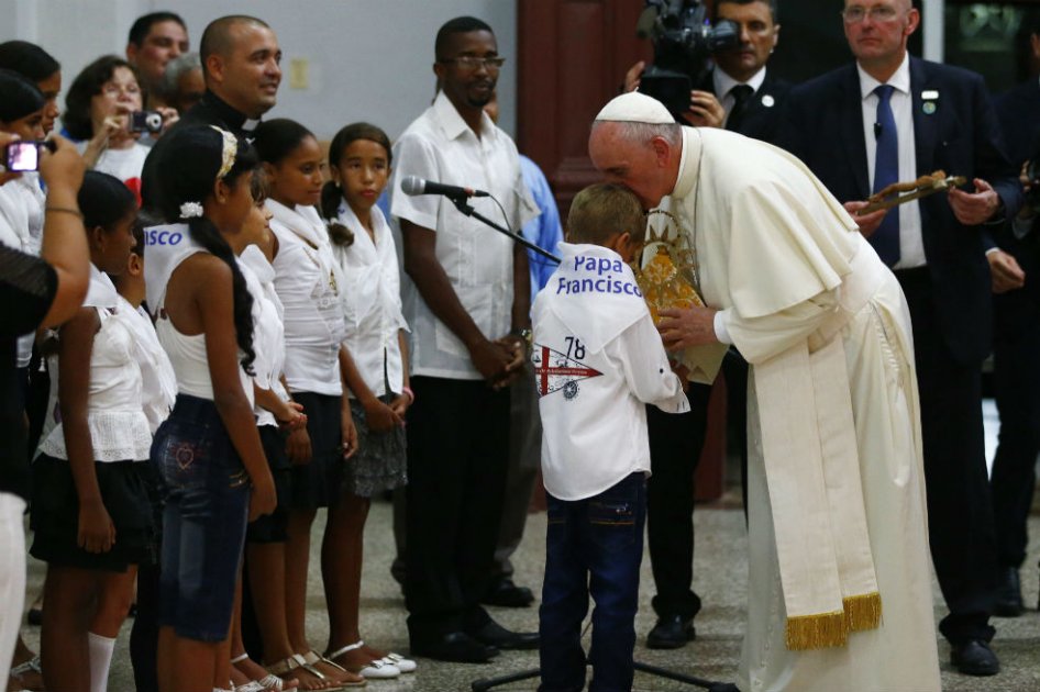 El papa Francisco recibe un regalo de un niño durante su visita al santuario de la Virgen de la Caridad del Cobre en Santiago de Cuba. /EFE