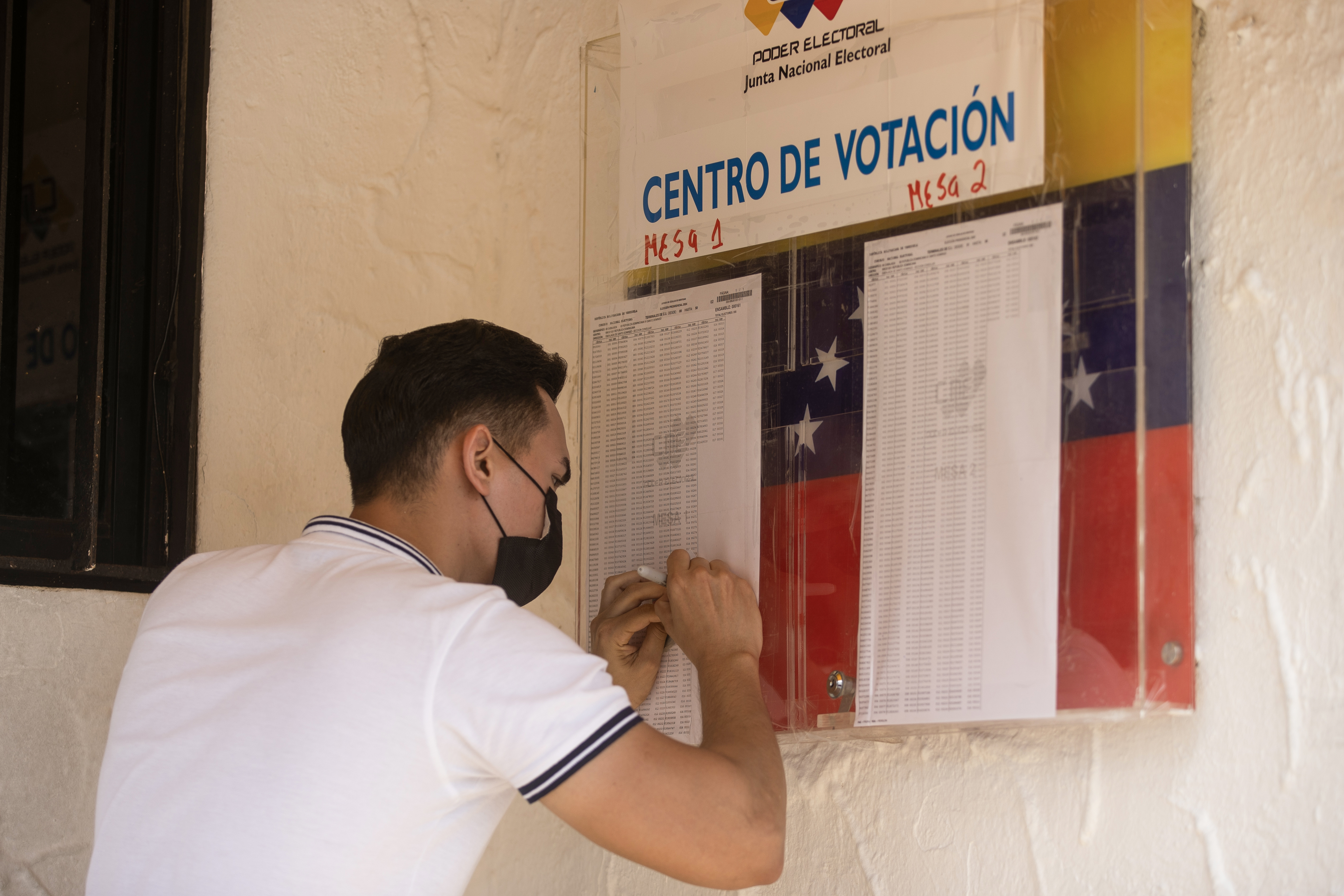 AME5725. SANTO DOMINGO (REPÚBLICA DOMINICANA), 28/07/2024.- Un funcionario de la embajada venezolana comprueba los datos de las personas votaron en las elecciones presidenciales de Venezuela este domingo, en Santo Domingo (República Dominicana). Los venezolanos residentes en la República Dominicana han acudido, en calma y tranquilidad, a las urnas para las elecciones convocadas en su país. EFE/Orlando Barría