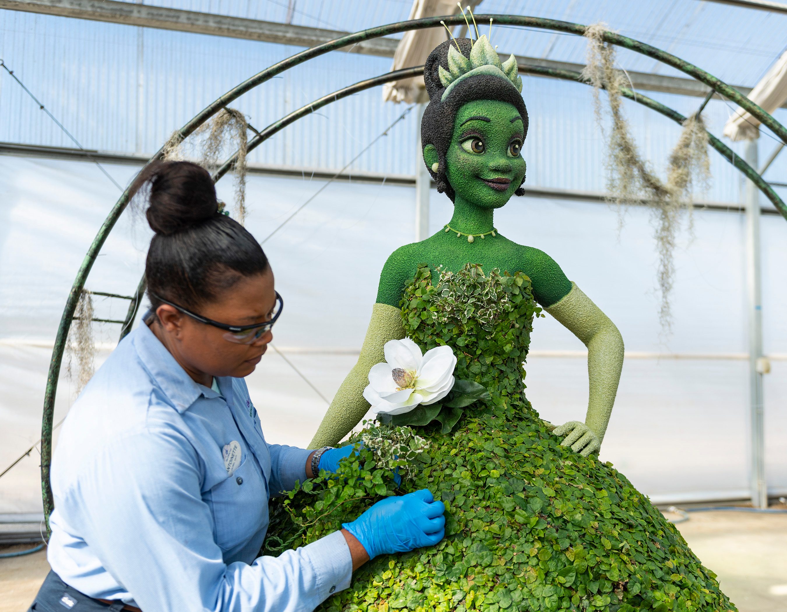 Un nuevo topiario de la Princesa Tiana del clásico Walt Disney Animation Studios adorna The American Adventure en World Showcase con un impresionante vestido de gala y luciérnagas iluminadas.