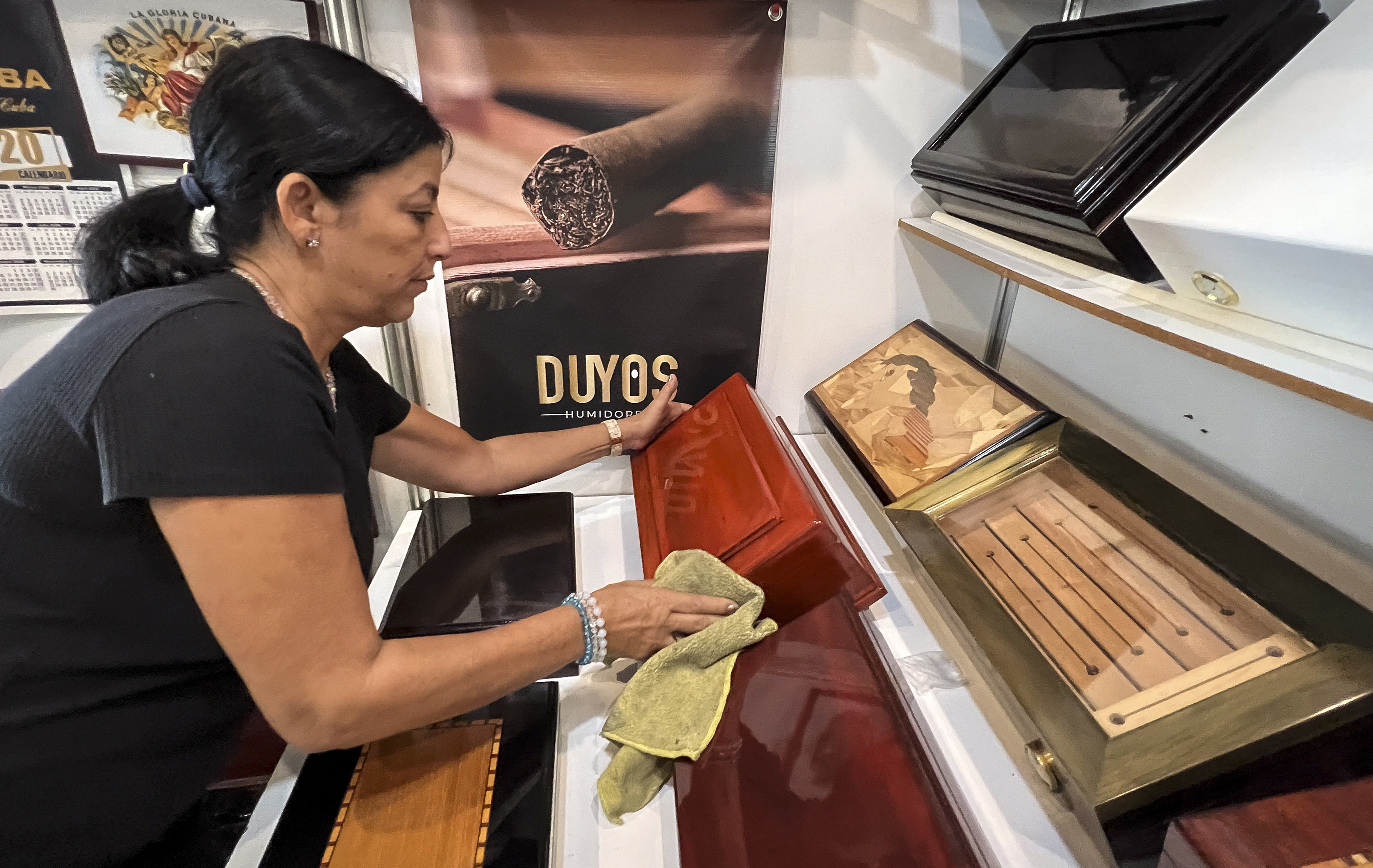 Tania Duyos, fabricante cubana de humidores de puros, desempolva sus productos.