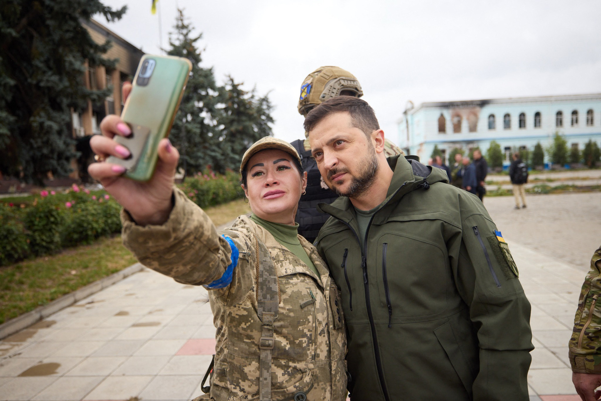 El presidente ucraniano Volodymyr Zelensky posando para una selfie con una militar en la ciudad desocupada de Izyum, región de Kharkiv.