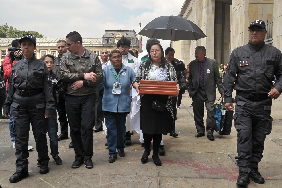 Rosa Milena Cárdenas llevando los restos de su madre, Luz Mary Portela, quien desapareció tras la retoma del Palacio de Justicia en 1985. A su izquerda, su hermano Édison.  / Santiago Acosta García
