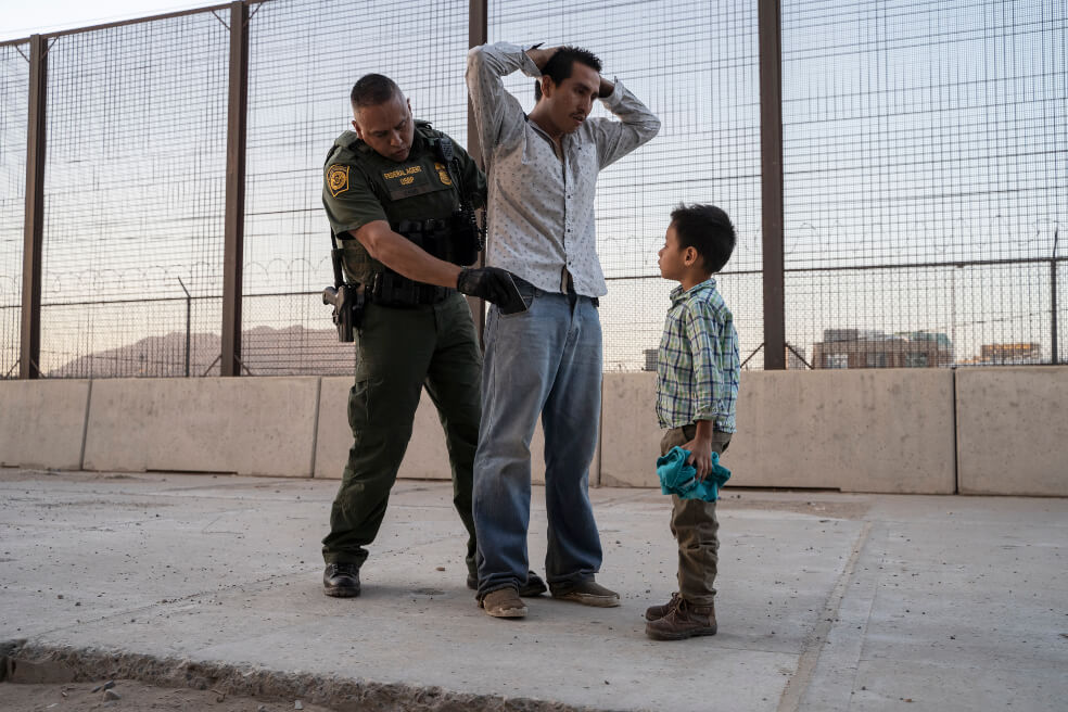 Un migrante, acompañado de su hijo de seis años, en El Paso (Texas) es detenido por agentes del Servicio de Inmigración y Aduanas.  / AFP