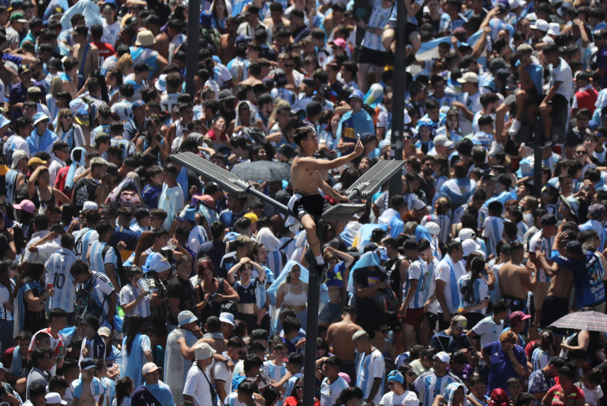 AMDEP9850. EZEIZA (ARGENTINA), 20/12/2022.- Un hincha de Argentina se toma una foto en un poste del alumbrado público hoy, en la celebración de la victoria de la selección argentina en el Mundial de Qatar 202, en una calle de Buenos Aires (Argentina). Argentina se proclamó campeona del mundo tras ganar en la tanda de penaltis (4-2) a Francia, después del empate 3-3 en los 120 minutos de juego. EFE/ Raúl Martínez