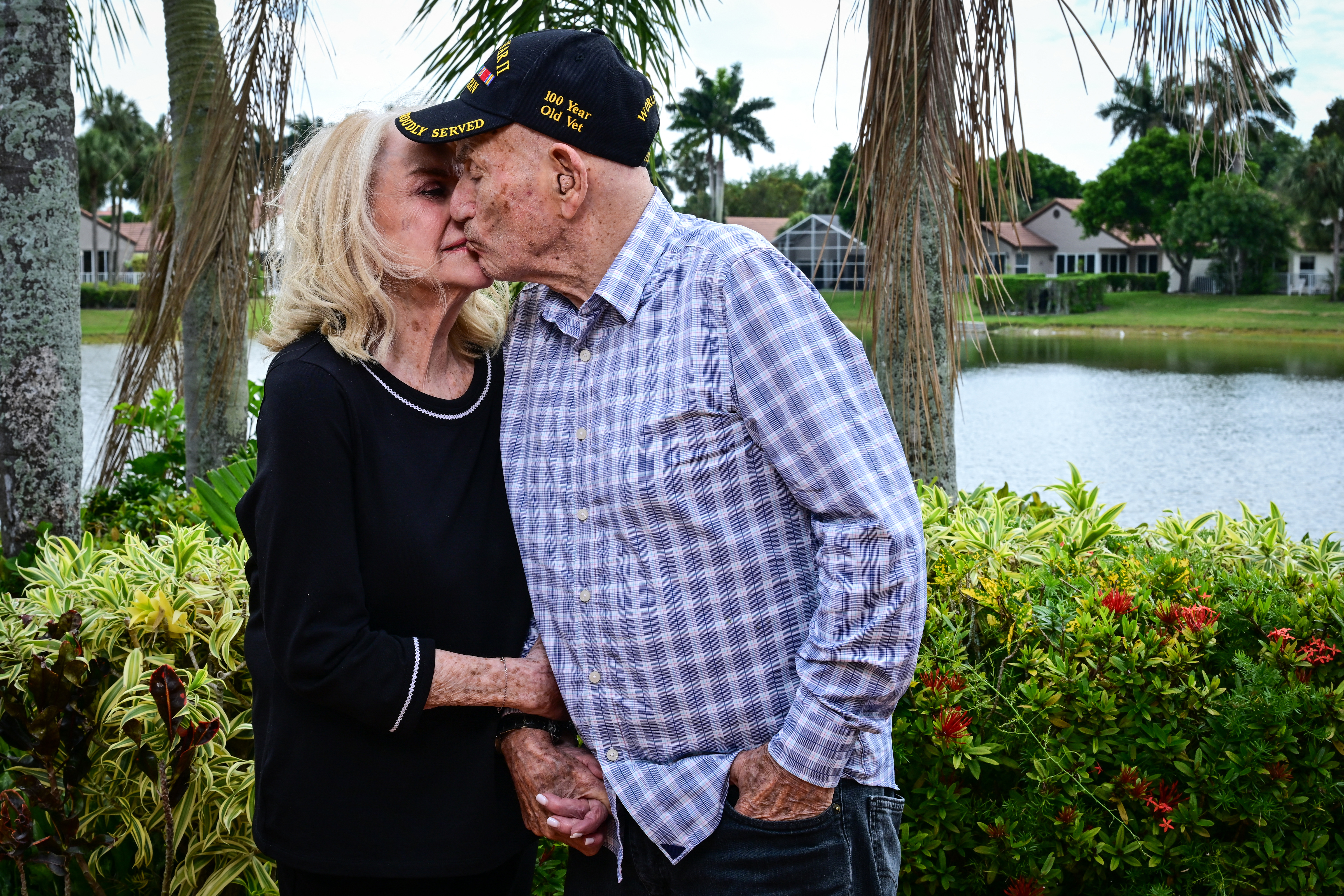 World War II veteran Harold Terens, 100, and his fiancee Jeanne Swerlin, 96, kiss during an interview, April 3, 2024, in Boca Raton, Florida.