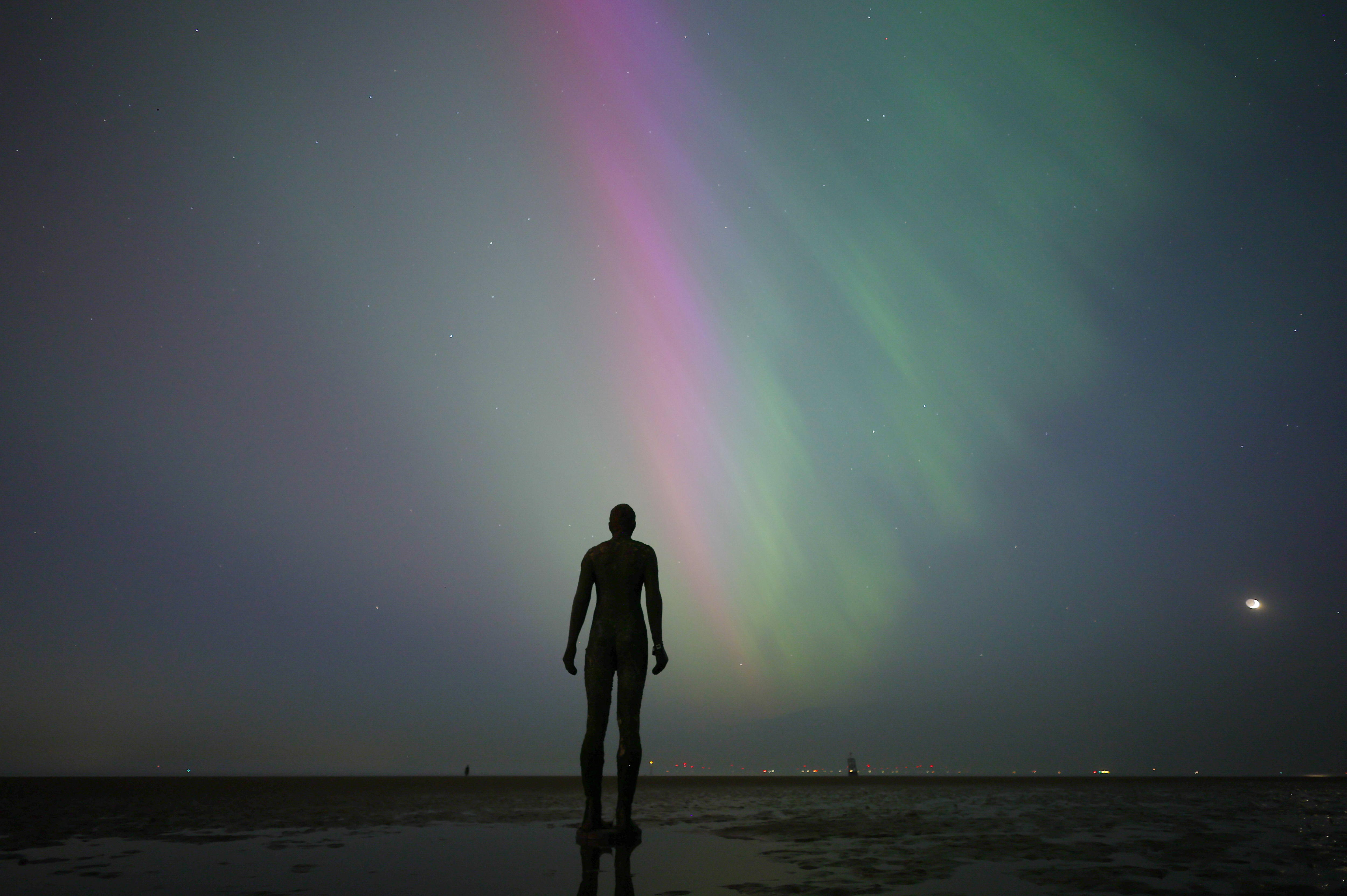Crosby (United Kingdom), 10/05/2024.- The Aurora Borealis, known as the Northern Lights, is visible in front of Anthony Gormley's "Another Place' sculpture in Crosby, Britain, 10 May 2024. The National Oceanic and Atmospheric Administration (NOAA) of America has warned that the strongest geomagnetic storm for 20 years is set to hit Earth, making the Aurora Borealis, or Northern Lights, visible at much lower geomagnetic latitudes than usual. (tormenta, Reino Unido) EFE/EPA/ADAM VAUGHAN