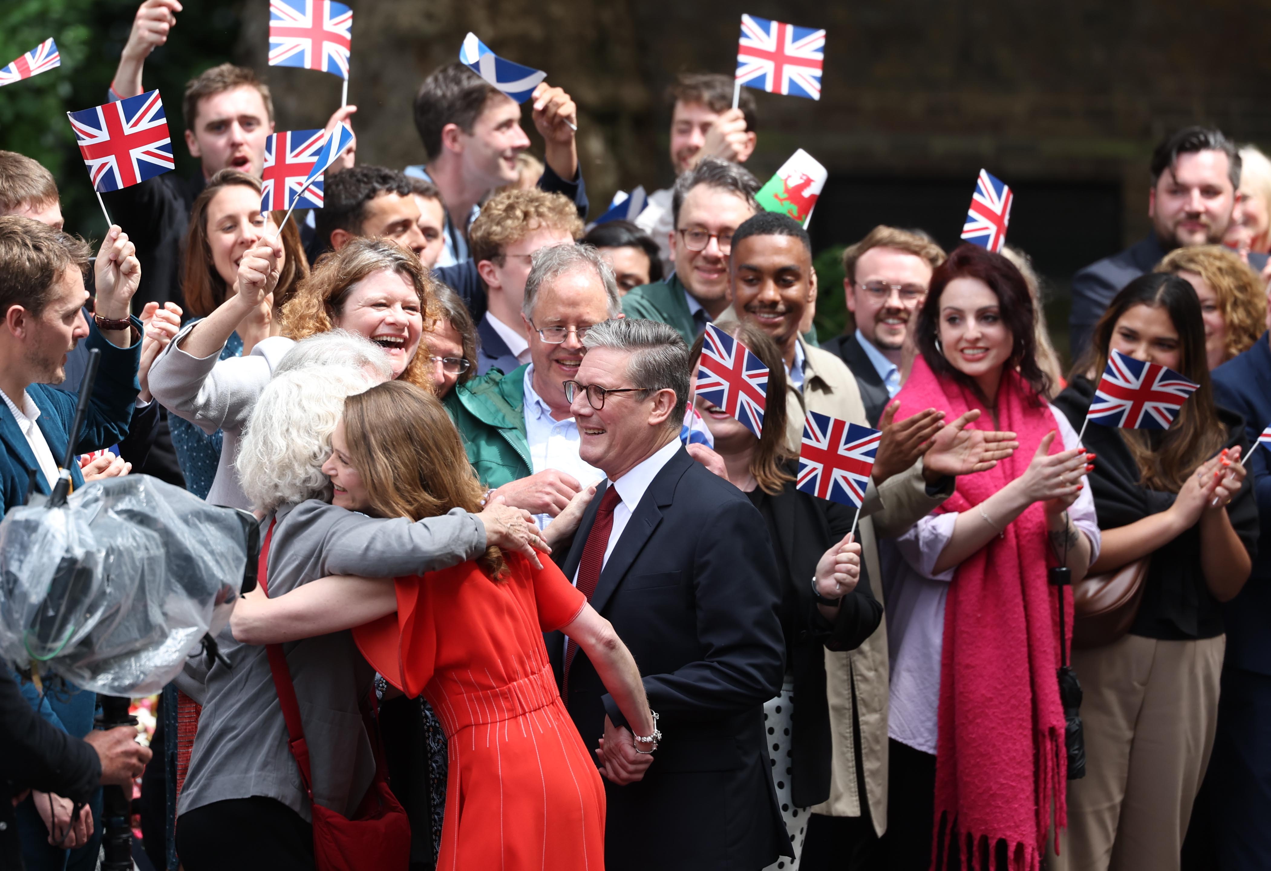 London (United Kingdom), 05/07/2024.- Britain's new Prime Minister Keir Starmer (C) and his wife Victoria Starmer (L) are greeted by well-wisher as they arrive at Downing Street in London, Britain, 05 July 2024. Labour party leader Keir Starmer became the country's new prime minister on 05 July, after his party won a landslide victory in the general election. (Elecciones, deslizamiento de tierras, Reino Unido, Londres) EFE/EPA/NEIL HALL