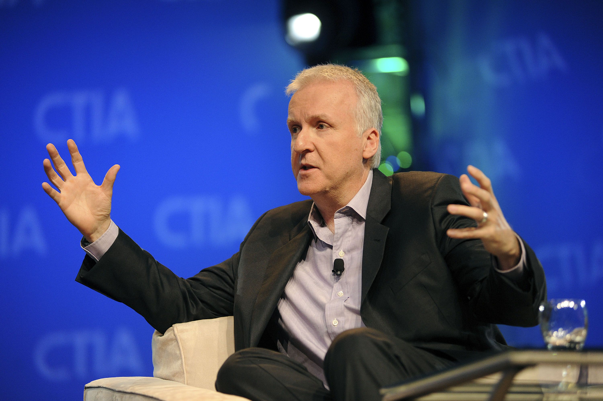 El director james Cameron se ve sentado sobre una silla durante una conferencia.