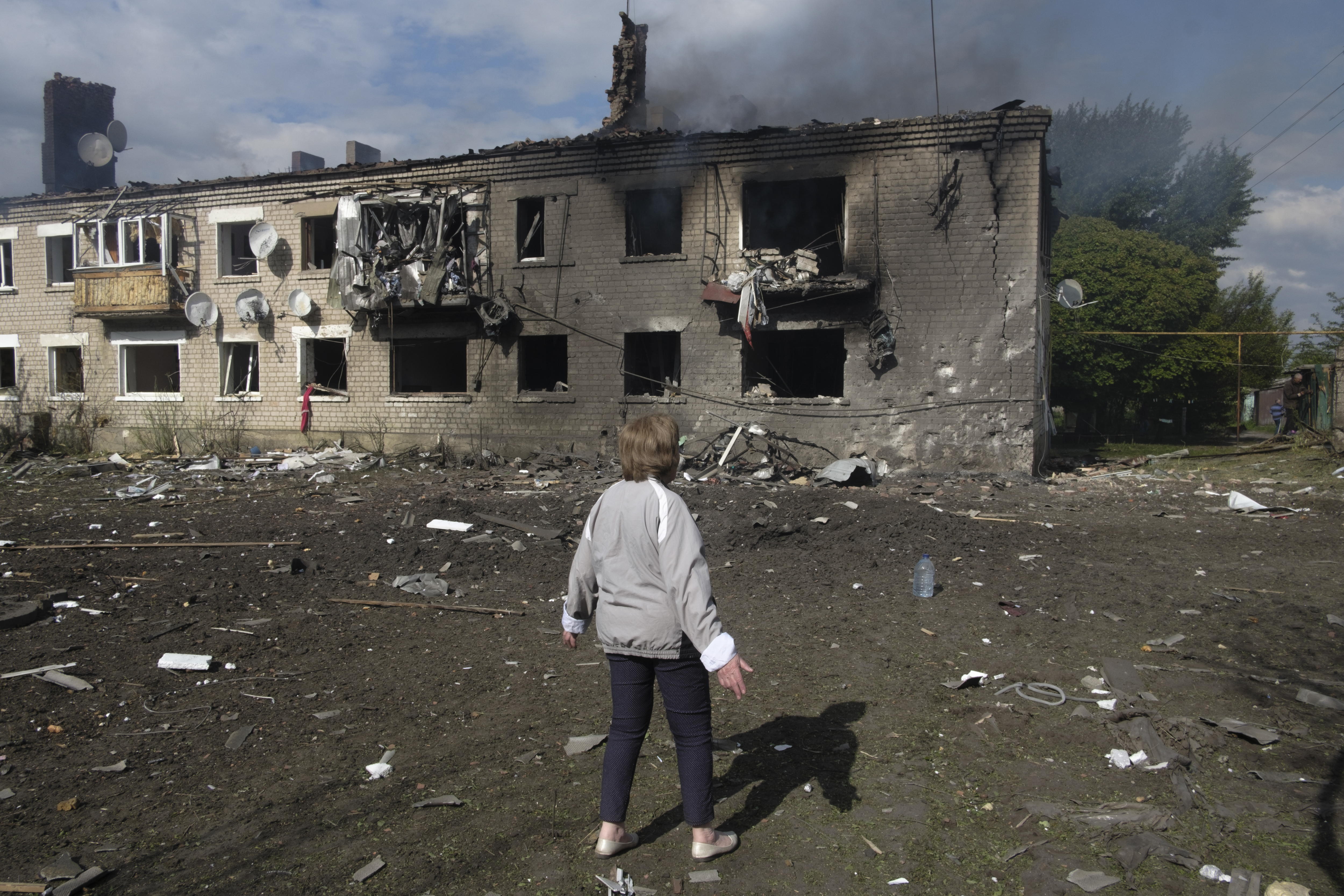 Kharkiv (Ukraine), 11/05/2024.- Tetyana looks at a building damaged during recent shelling on the outskirts of Volchans, Kharkiv region, Ukraine, 11 May 2024, amid the Russian invasion. Tetyana, along with others, decided not to evacuate but remain in the village instead, regardless of local authority'Äôs advice. More than 1,700 people were evacuated from border areas in Ukraine's Kharkiv following incursions by the Russian army. According to the head of the Kharkiv Military Administration Oleg Synegubov, Russian troops have increased shelling and are trying to attack Ukrainian positions in the northern Kharkiv area. (Rusia, Ucrania) EFE/EPA/GEORGE IVANCHENKO