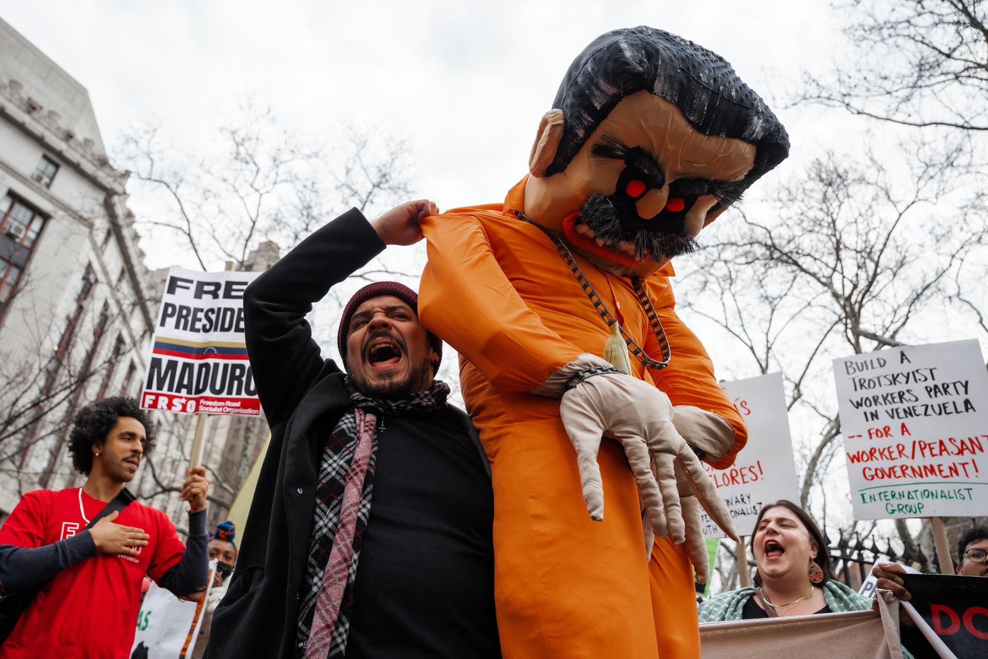 New York (United States), 26/03/2026.- A member of the Venezuelan diaspora carries a puppet representing former President of Venezuela Nicolas Maduro past Maduro's supporters during dueling protests outside a federal courthouse where he is expected to appear before a judge in New York, New York, USA, 26 March 2026. Maduro was captured along with his wife, Cilia Flores by US forces in a military operation in Caracas on 03 January 2026. (Protestas, Nueva York) EFE/EPA/Olga Fedorova