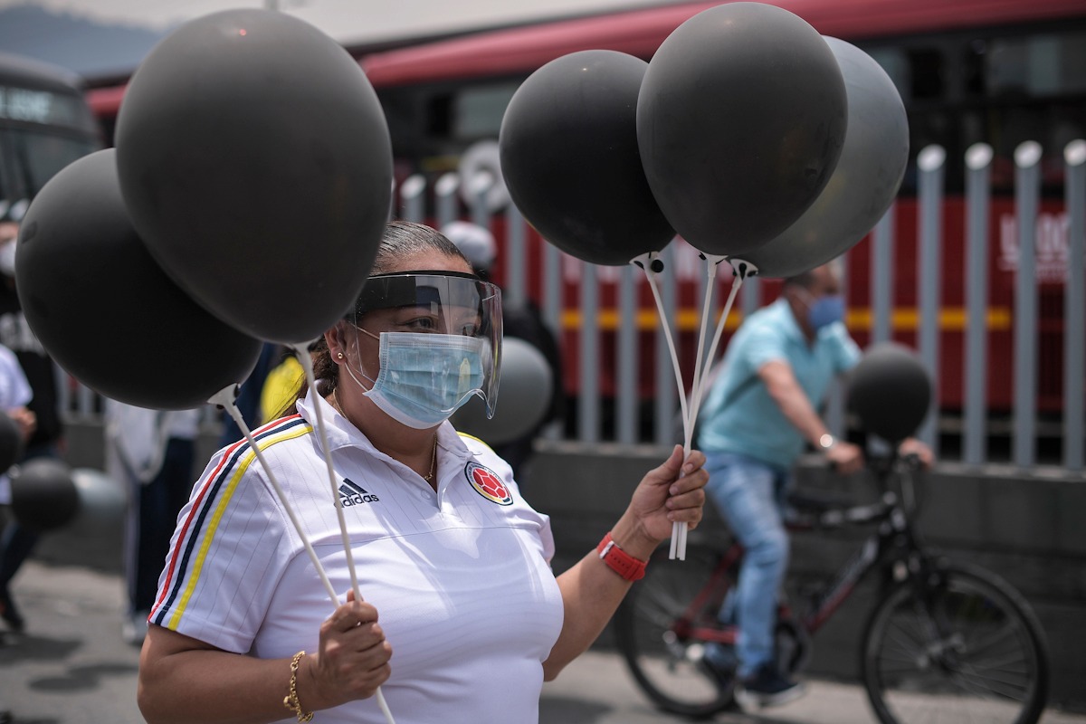 Una mujer con globos negros en las manos.