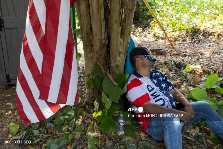 Un seguidor del expresidente Donald Trump se echa una siesta mientras espera su llegada fuera de la cárcel del condado de Fulton en Atlanta, Georgia, el 24 de agosto de 2023. El expresidente de EE.UU. Donald Trump se dirige a Georgia el 24 de agosto para enfrentarse a cargos de chantaje y conspiración y probablemente someterse a una histórica foto de ficha policial.
Trump, de 77 años, será arrestado en la cárcel del condado de Fulton, en Atlanta, acusado de confabularse con 18 coacusados para intentar anular el resultado de las elecciones de 2020 en el estado clave del sur. (Foto de Christian MONTERROSA / AFP)