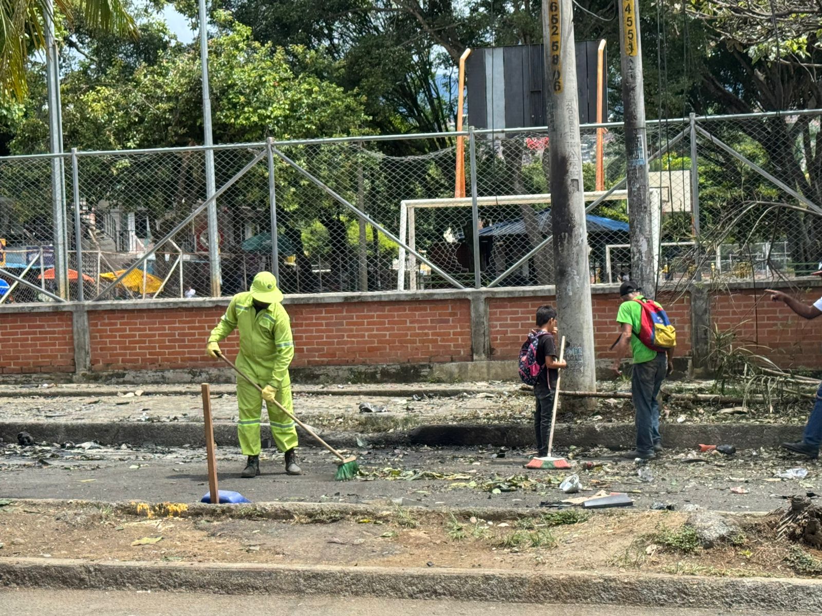 Dylan, vestido de negro, ayudando a limpiar los escombros tras la explosión.