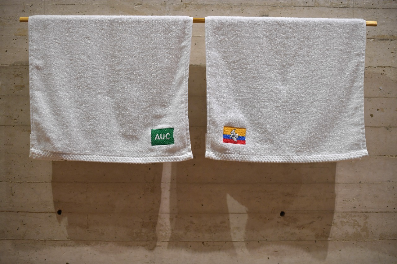 Toallas con las banderas de las AUC y las FARC-EP, piezas que hacen parte de “Venseremos”.