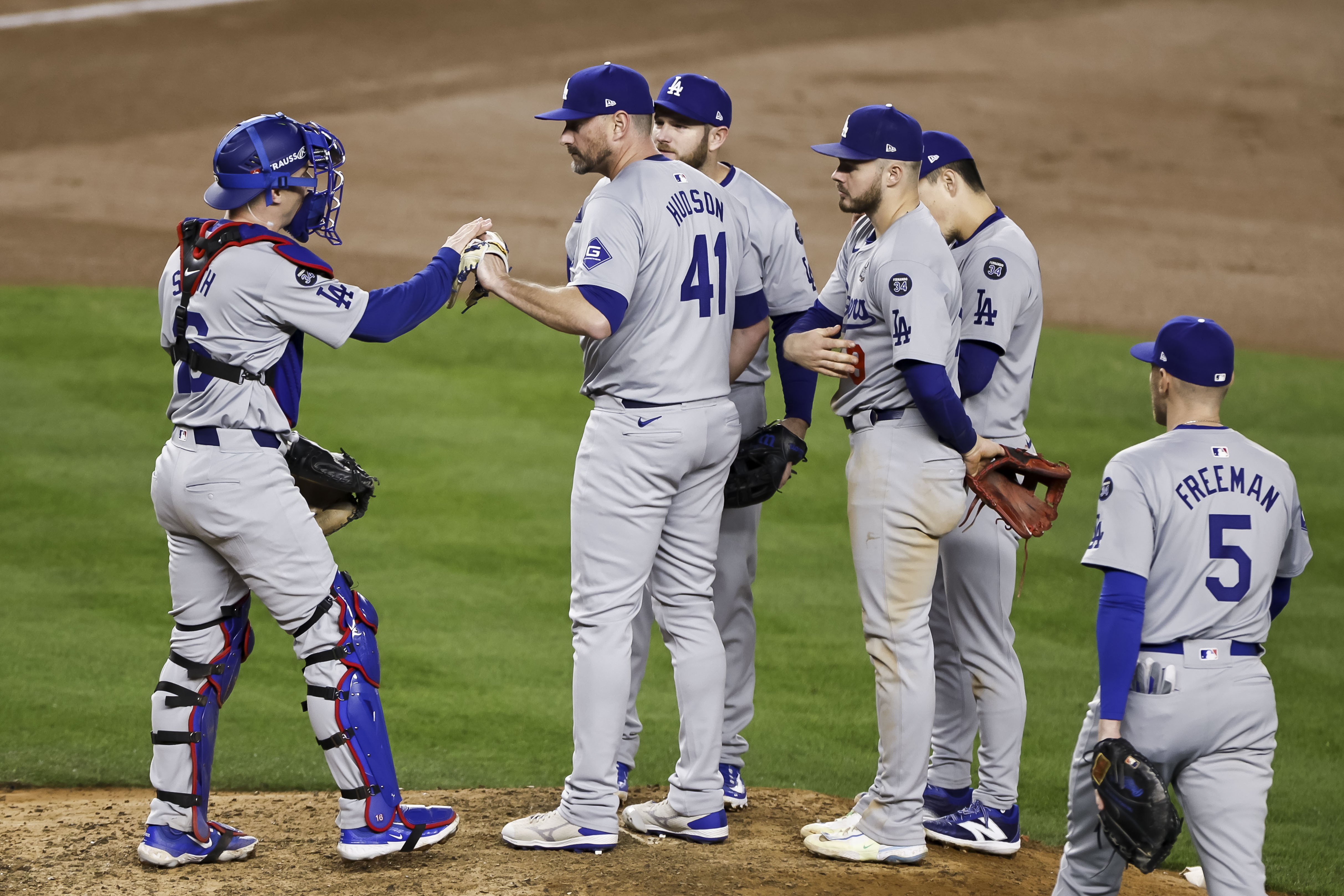 New York (United States), 28/10/2024.- Dodgers catcher Will Smith (L) hands the ball to Dodgers pitcher Daniel Hudson (2-L) as his teammates look on before Hudson is taken out of the game in the seventh inning of game three of the Major League Baseball (MLB) World Series between the American League Champion New York Yankees and the National League Champion Los Angeles Dodgers at Yankees Stadium in the Bronx borough of New York, New York, USA, 28 October 2024. The World Series is the best-of-seven games. (Nueva York) EFE/EPA/CJ GUNTHER