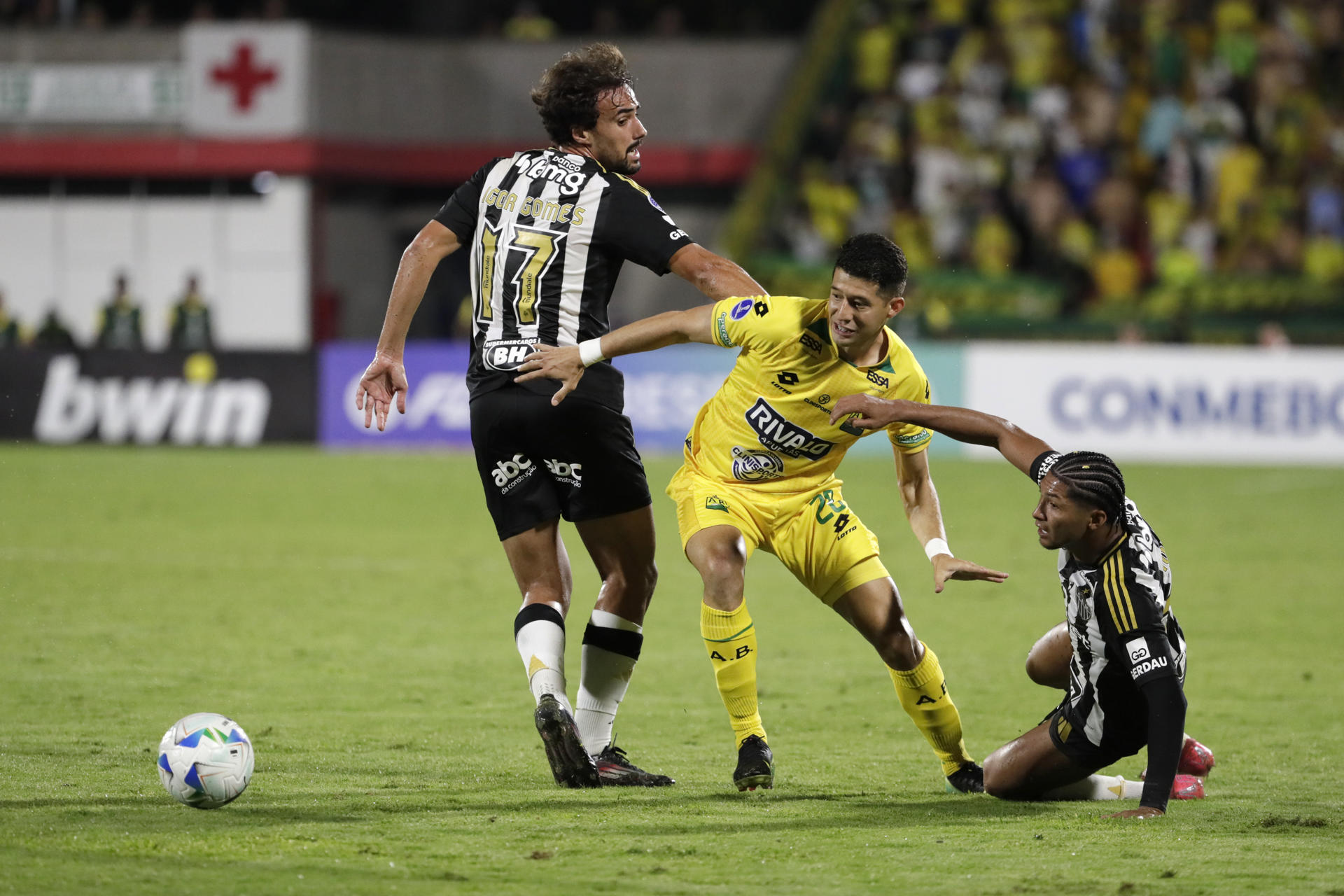 AMDEP8552. BUCARAMANGA (COLOMBIA), 17/07/2025.- Leonardo Flores (c) de Bucaramanga disputa el balón con Ronielson da Silva (d) y Igor Gomes de Mineiro este jueves, durante un partido de la eliminatoria para los octavos de final de la Copa Sudamericana entre Bucaramanga y Atlético Mineiro en el estadio Departamental Américo Montanini en Bucaramanga (Colombia). EFE/ Carlos Ortega