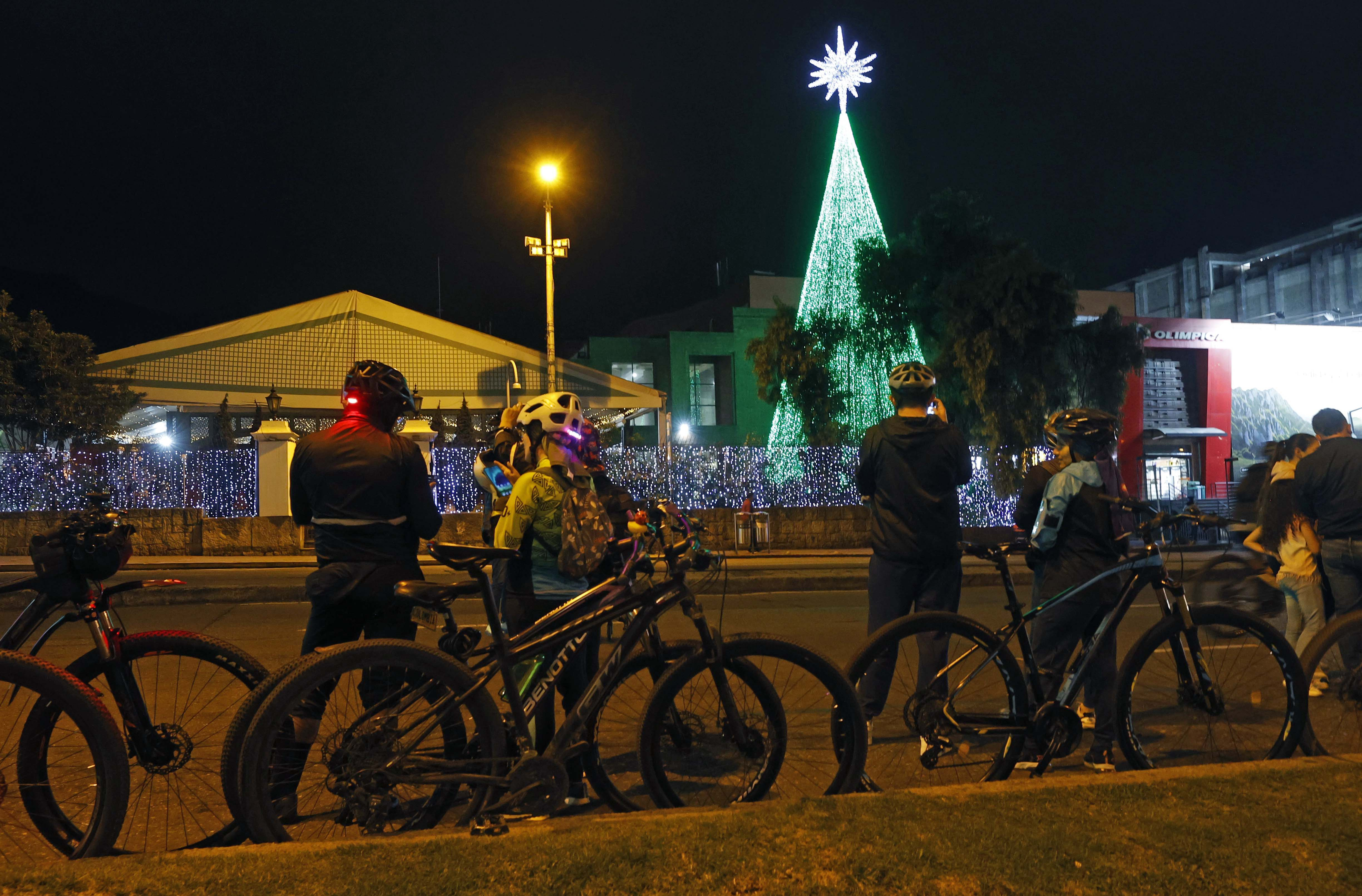 AME5143. BOGOTÁ (COLOMBIA), 12/12/2024.- Ciclistas observan decoración navideña este jueves, durante una jornada de ciclovía nocturna en Bogotá (Colombia). Los bogotanos podrán recorrer más de los 90 kilómetros de vías habilitadas y disfrutar el alumbrado navideño y actividades recreativas en puntos estratégicos EFE/ Mauricio Dueñas Castañeda