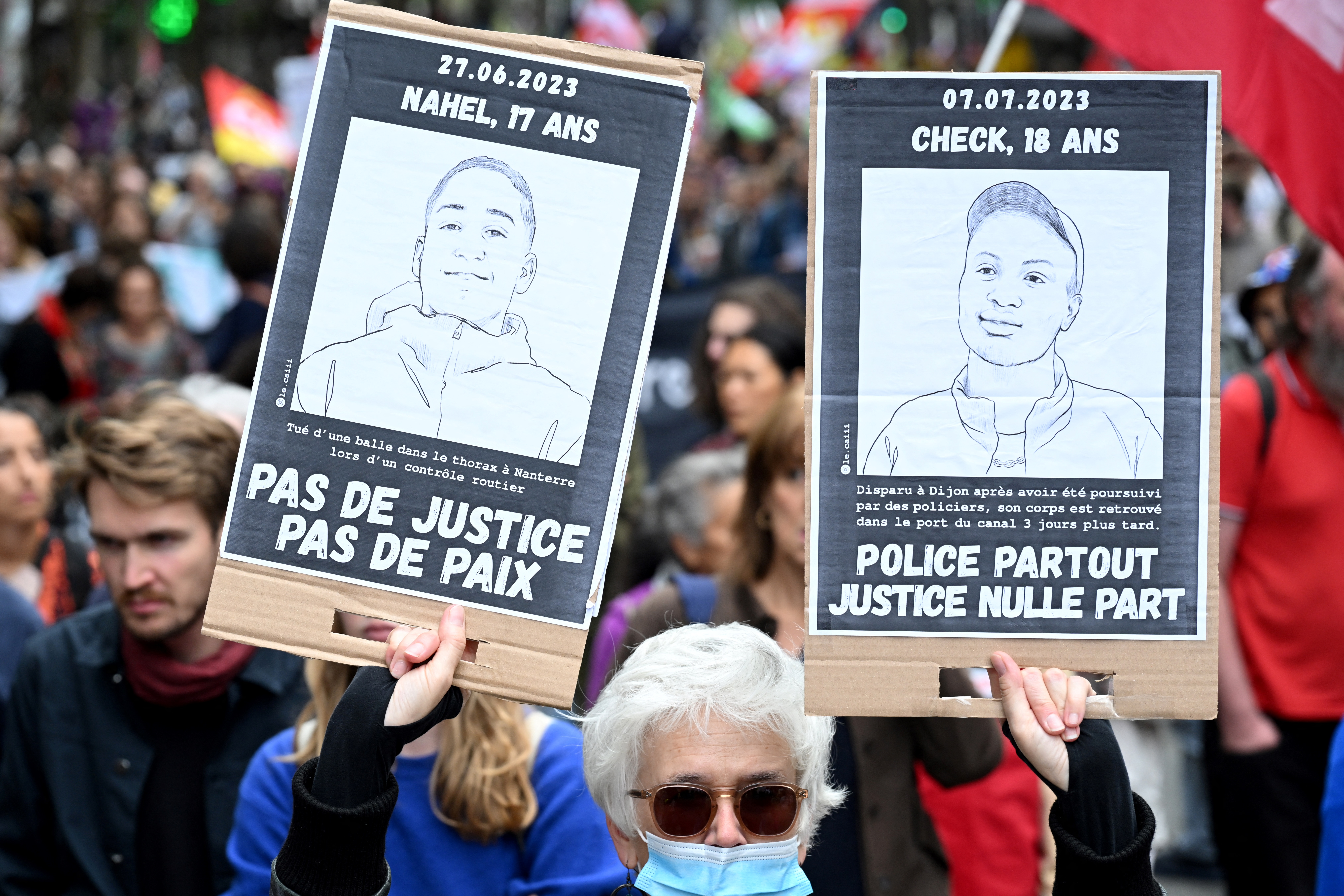 A protestor holds portraits of victims of alleged French police violence during a "united march" against police brutality called by NGOs, unions and parties, in Paris on September 23, 2023. Around 30,000 people are expected in several French cities on September 23, 2023 for demonstrations "against systemic racism, police violence and for public freedoms", called by the far left and various organizations, under heavy police surveillance. (Photo by Bertrand GUAY / AFP)