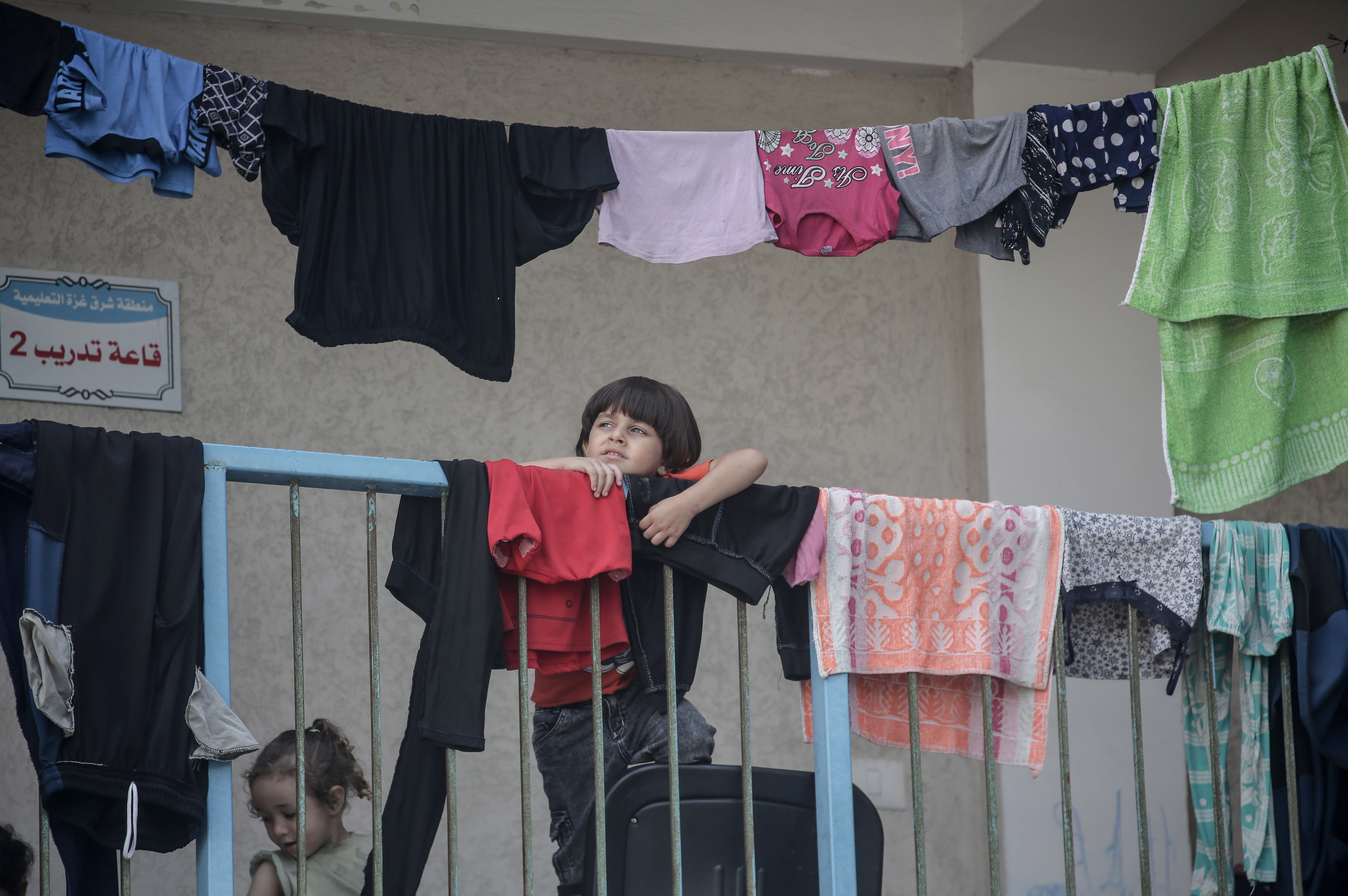 Gaza (-), 08/10/2023.- A Palestinian child looks on as people gather at an UNRWA school after they fled following Israeli strikes in the northern and eastern Gaza Strip, in Gaza City, 08 October 2023. According to the UNRWA, over 20,000 Internally Displaced People were sheltering in 44 UNRWA schools in all areas in the Gaza Strip, except Khan Younis. The Islamist movement Hamas on 07 October launched a surprise attack on Israel, in which more than 300 Israelis were killed and over 1,000 left injured, according to the Israeli foreign ministry. Israeli air strikes in retaliation for rocket attacks have killed over 300 people in the Gaza Strip, with almost 2,000 wounded, according to Palestinian official sources. EFE/EPA/HAITHAM IMAD
