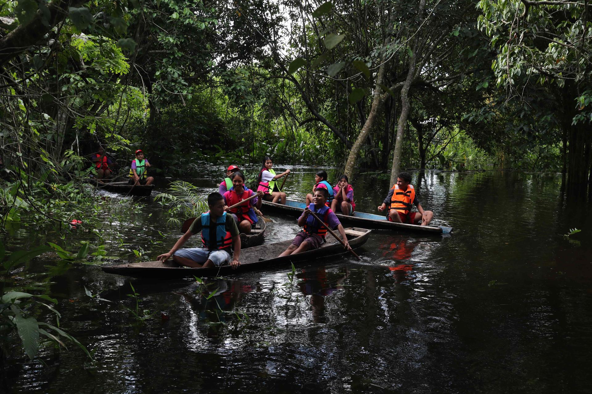 ACOMPAÑA CRÓNICA : PERÚ MEDIO AMBIENTE AME1146. LIMA (PERÚ), 27/05/2025.- Fotografía del 1 de mayo de 2025 de un grupo de niños en canoas dirigiéndose a un vivero por el rio Itaya, en Iquitos (Perú). Un colorido ejército de niños en canoas surge entre la vegetación en el río Itaya, en el corazón de la Amazonía peruana. Al vivir en el pulmón del mundo, saben que la deforestación y el cambio climático no son sólo fenómenos que estudian, sino que sufren directamente sus efectos, por lo que han decidido organizarse y ser herramienta de cambio. EFE/ Paolo Aguilar
