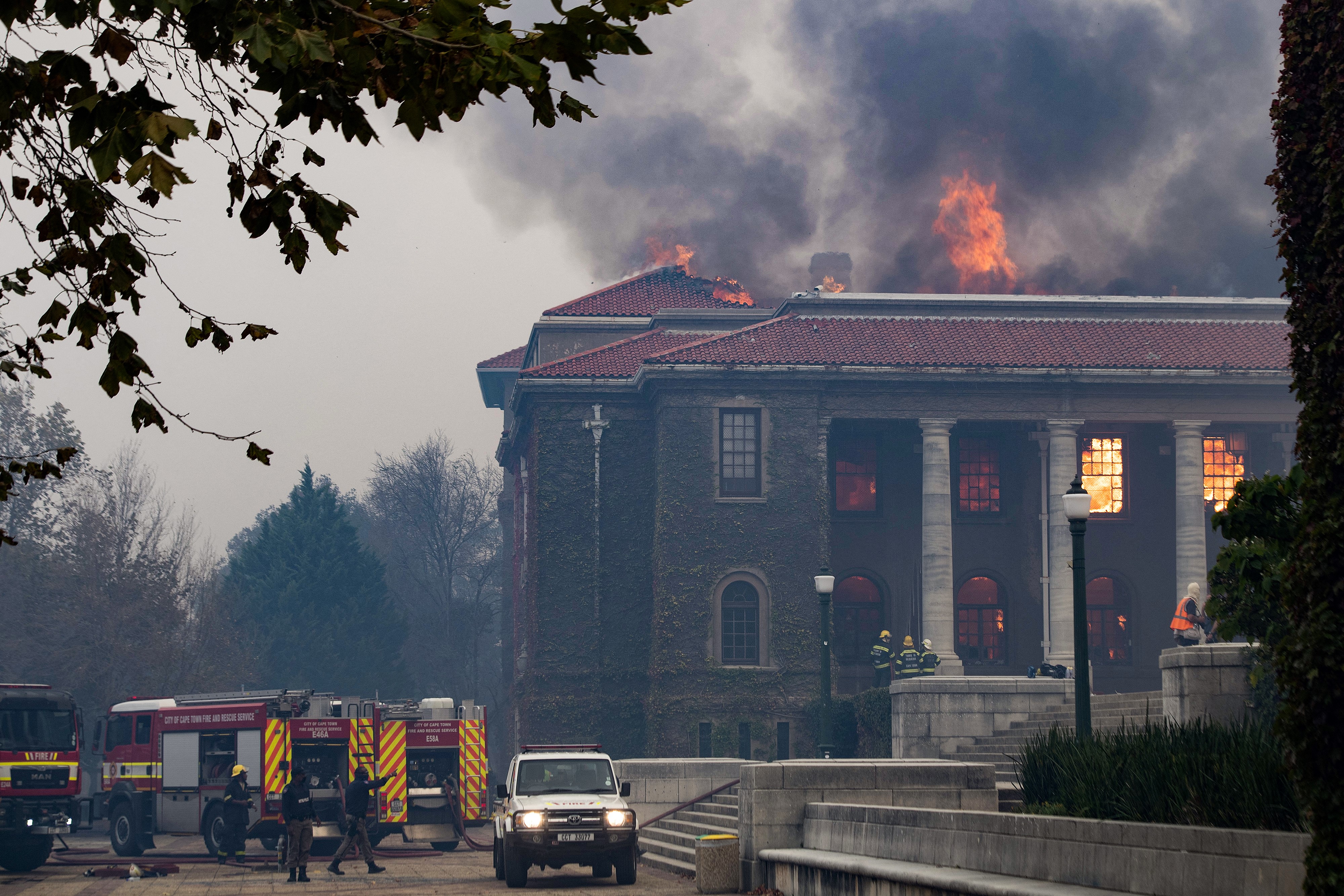 Los bomberos intentan, en vano, extinguir un incendio en la Biblioteca Jagger, en la Universidad de Ciudad del Cabo, luego de que un incendio forestal bajara las estribaciones de Table Mountain, incendiando edificios universitarios en Ciudad del Cabo, el 18 de abril de 2021.