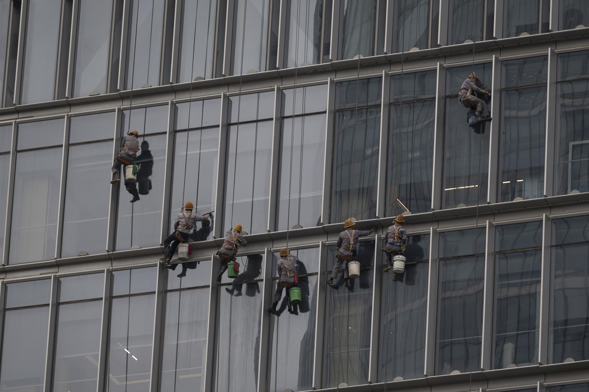 BEIJING (China), 15/07/2025.- Window cleaners hanging from ropes clean the facade of a building in Beijing, China, 15 July 2025. EFE/EPA/ANDRES MARTINEZ CASARES