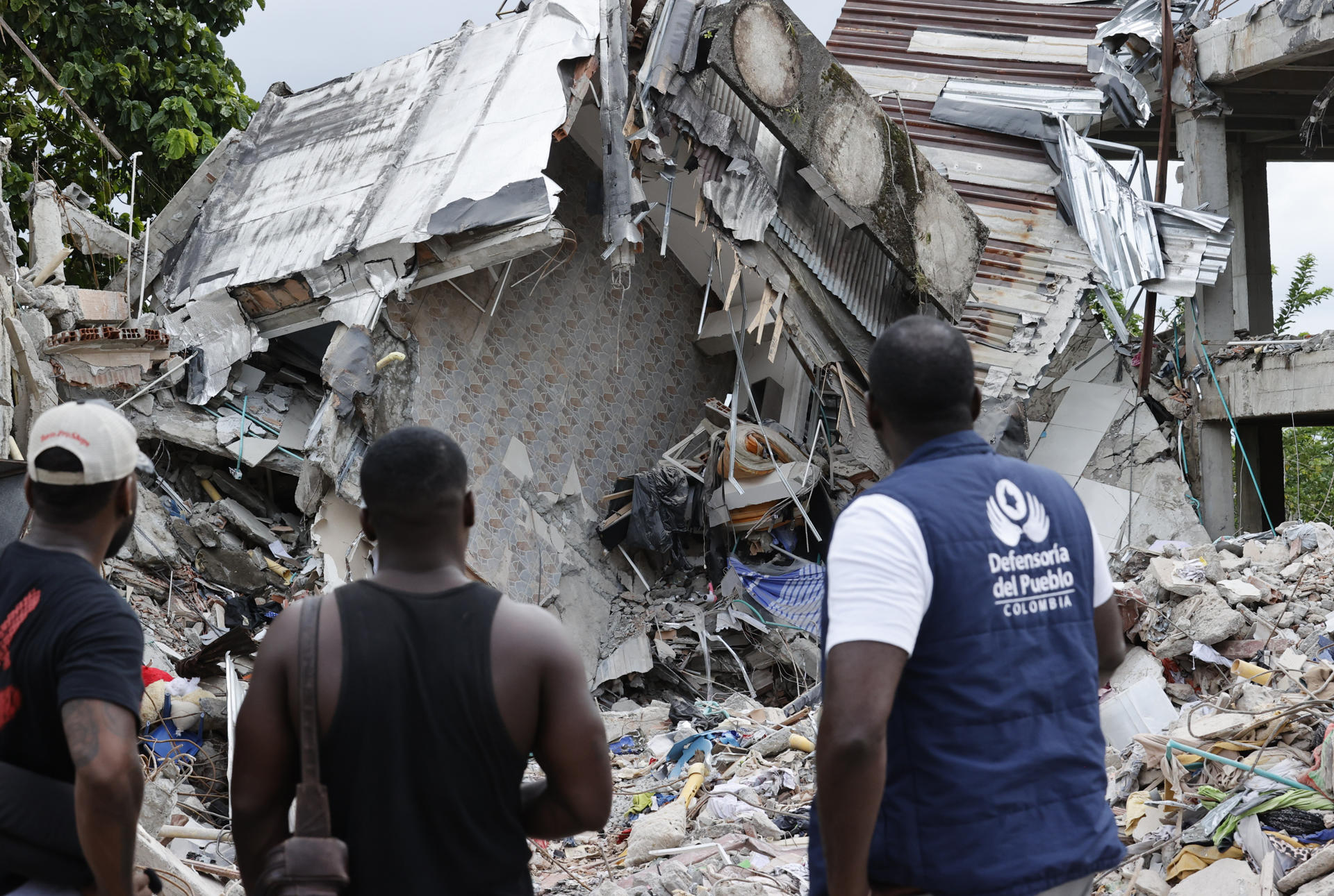 AME8684. QUIBDÓ (COLOMBIA), 12/08/2026.- Personas observan un edificio destruido por el terremoto este miércoles, en Quibdó, Chocó (Colombia). Durante un recorrido por los sectores afectados de Quibdó, capital del departamento del Chocó, en el que estuvo EFE, la defensora del Pueblo de Colombia, Iris Marín dijo que, aunque las autoridades locales dieron por finalizadas las labores de búsqueda y rescate, la emergencia entra ahora en una etapa en la que es necesario determinar con precisión el número de personas damnificadas y sus necesidades. EFE/ Mauricio Dueñas Castañeda
