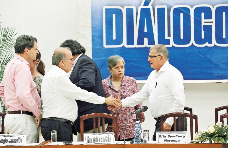 Sergio Jaramillo, comisionado de Paz, y Humberto de la Calle, jefe negociador del Gobierno, saludan a “Rodrigo Granda”, el jueves en La Habana. / EFE