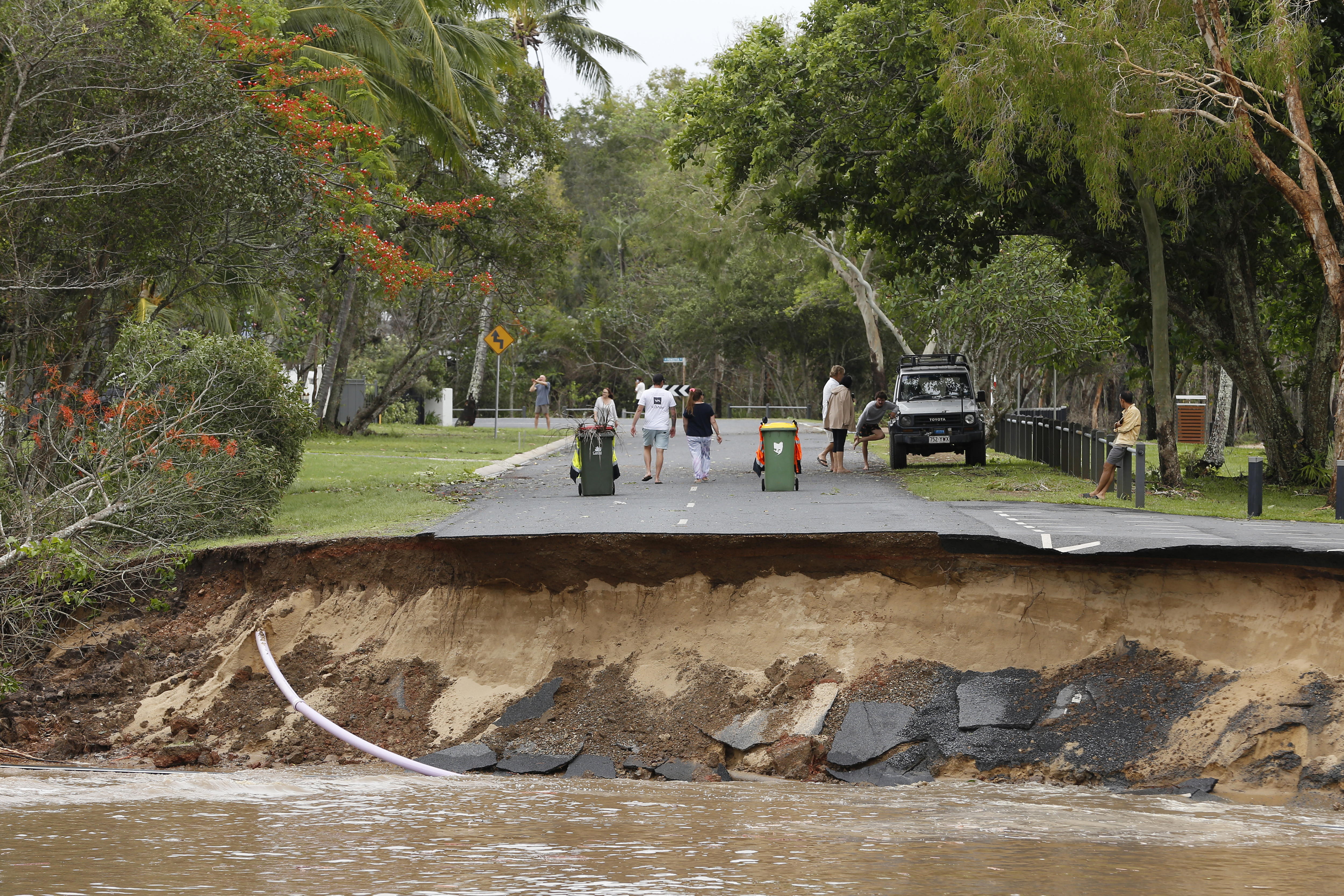 Cairns (Australia), 17/12/2023.- Residents walk near a section of a road that was washed away at the end of Holloways Beach Esplanade in Cairns, Queensland, Australia, 18 December 2023. Residents in far north Queensland are bracing for more rain and further significant flooding. EFE/EPA/JOSHUA PRIETO AUSTRALIA AND NEW ZEALAND OUT
