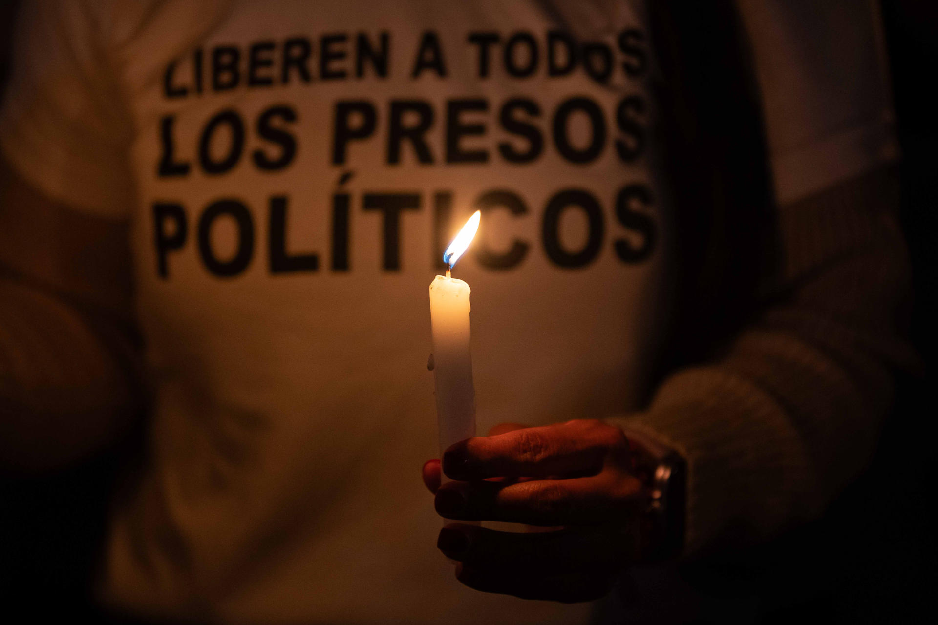 AME7866. ZAMORA (ESPAÑA), 23/01/2026.-Una persona sostiene una vela en una vigilia frente al centro penitenciario Rodeo I este viernes, en Zamora estado de Miranda (Venezuela). Unas 80 familias han pernoctado a las afueras del penal El Rodeo I desde el pasado 8 de enero, cuando autoridades anunciaron excarcelaciones en Venezuela, y cumplen este viernes la decimosexta noche de vigilia, tiempo en el que han exigido la liberación de sus parientes presos políticos. EFE/ Ronald Peña R