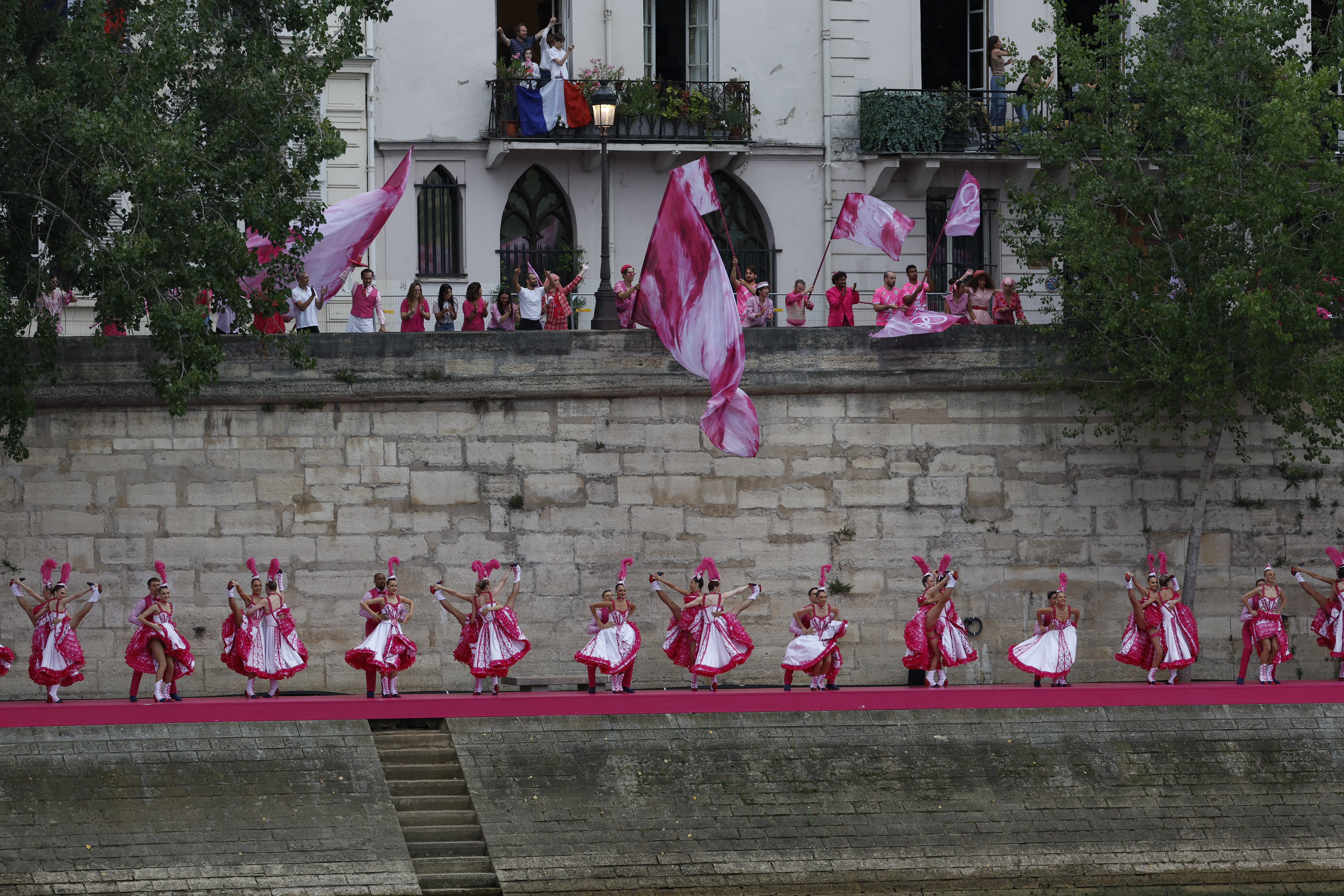 PARÍS (FRANCIA), 26/07/2024.- Varios artistas bailan el cancán a orillas del río Sena al paso de la selecciones olímpicas durante la ceremonia de inauguración de los Juegos Olímpicos de París 2024, este viernes en la capital francesa. EFE/Julio Muñoz