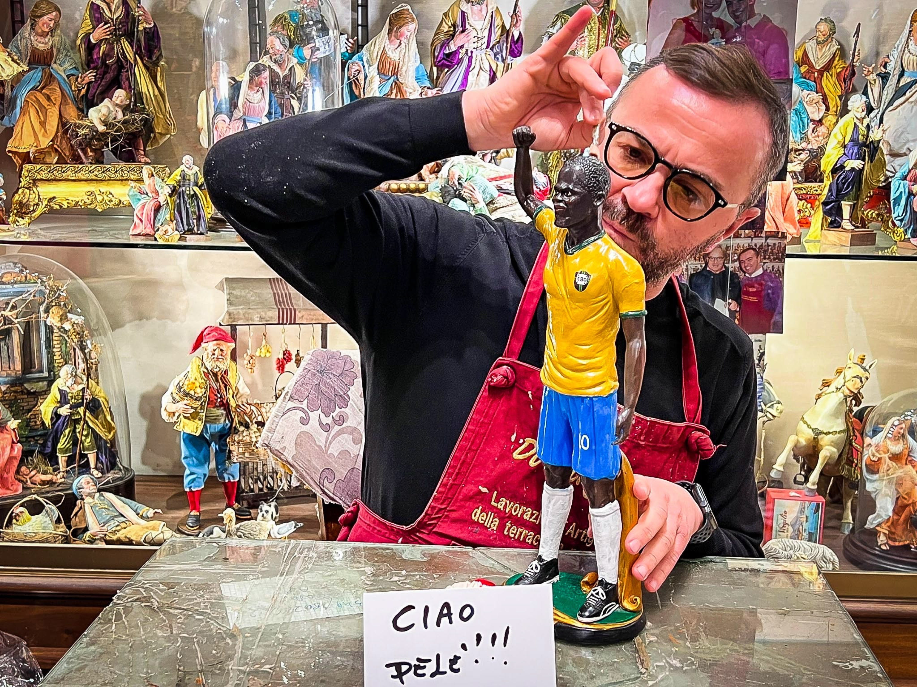 Naples (Italy), 30/12/2022.- Italian cribs craftsman Genny Di Virgilio works on a Nativity figurine of late Brazilian soccer legend Pele at his workshop in Naples, Italy, 30 December 2022. The statuette depicts Pele with the green-gold shirt of the Brazil national team and his hand raised as a sign of exultation. A sign on the table reads 'Ciao Pele!!!'. Pele, born Edson Arantes do Nascimento, died at the age of 82 on 29 December 2022. (Brasil, Italia, Nápoles) EFE/EPA/CESARE ABBATE