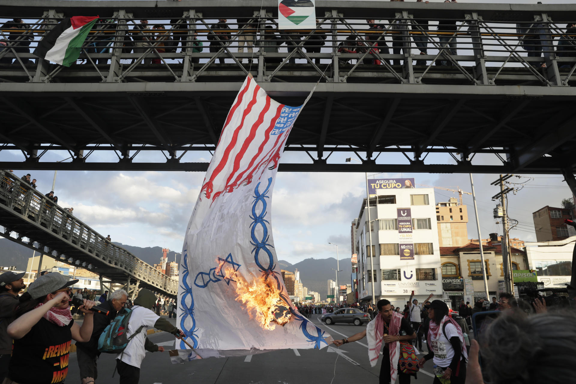 AME5688. BOGOTÁ (COLOMBIA), 07/10/2025.- Personas prenden fuego a una bandera durante una manifestación en apoyo a Palestina con motivo del segundo aniversario del ataque de Hamás contra Israel, este martes en Bogotá (Colombia). EFE/ Carlos Ortega
