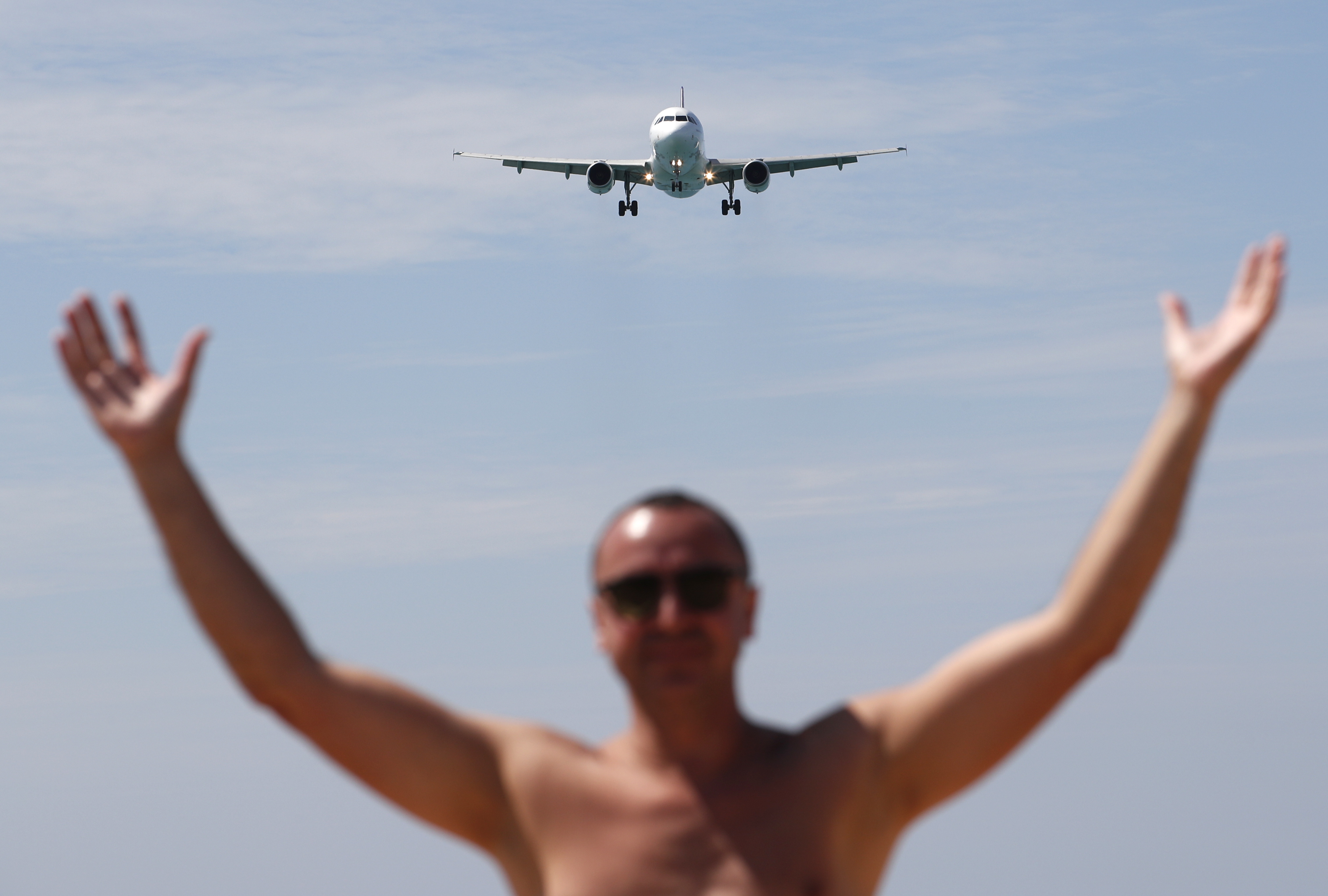 -FOTODELDÍA- EA3262. PHUKET (TAILANDIA), 25/12/2024.- Un turista posa en una playa mientras un avión se aproxima para aterrizar en el aeropuerto internacional de Phuket este miércoles, en la isla de Phuket (Tailandia). Tailandia ha recibido este año a 32,7 millones de turistas extranjeros hasta diciembre de 2024, según el portavoz del Gobierno, mientras que la Oficina de Phuket de la Autoridad de Turismo de Tailandia (TAT) afirma que se espera que los ingresos del destino turístico de la isla de Phuket alcancen los 500.000 millones de baht (14.000 millones de dólares o 14.000 millones de euros). EFE/EPA/ Rungroj Yongrit