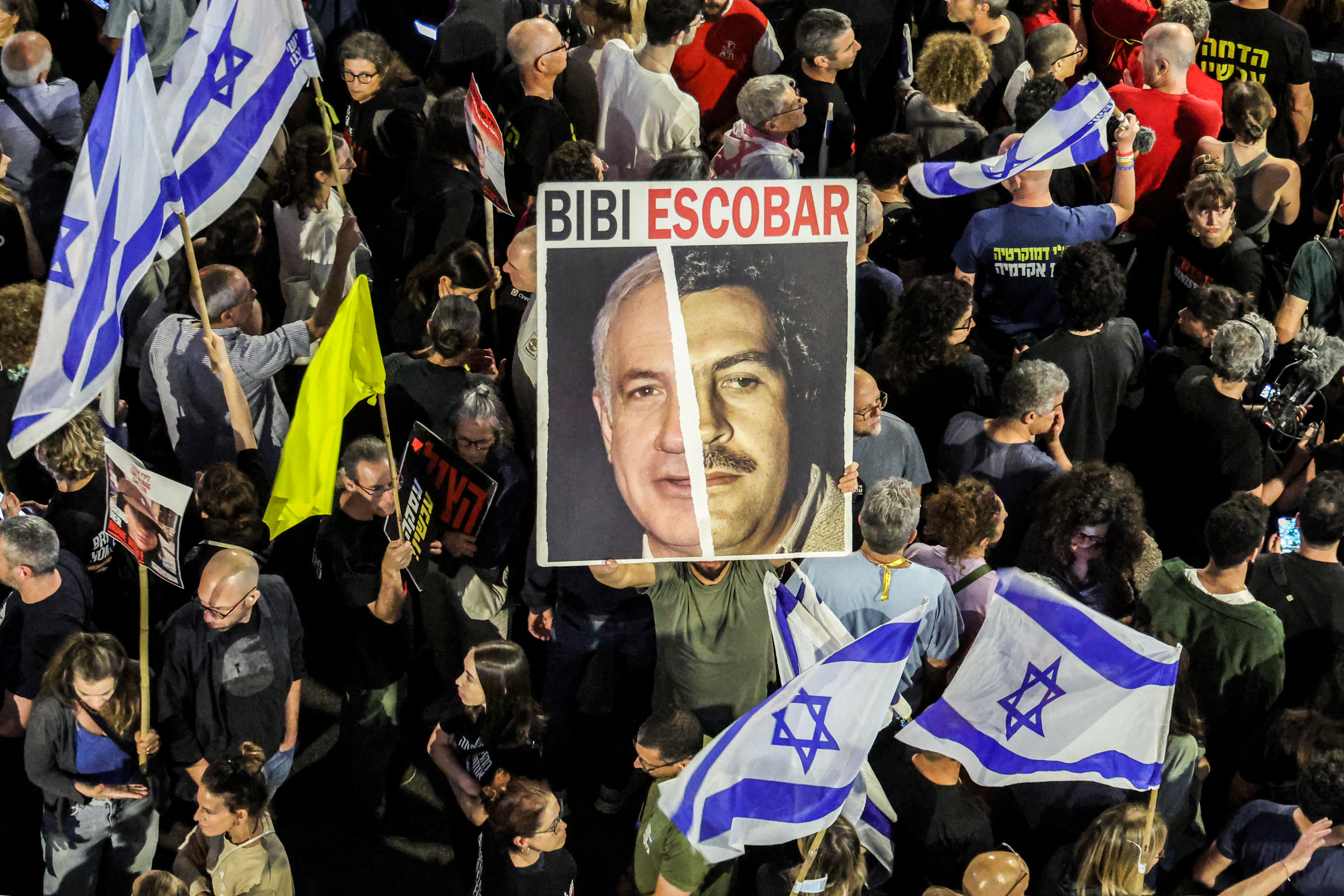 Un manifestante sostiene un cartel que representa una mezcla de los rostros del primer ministro israelí Benjamin Netanyahu y del narcotraficante colombiano Pablo Escobar durante una manifestación de familiares de los rehenes en poder de Hamás desde el 7 de octubre.