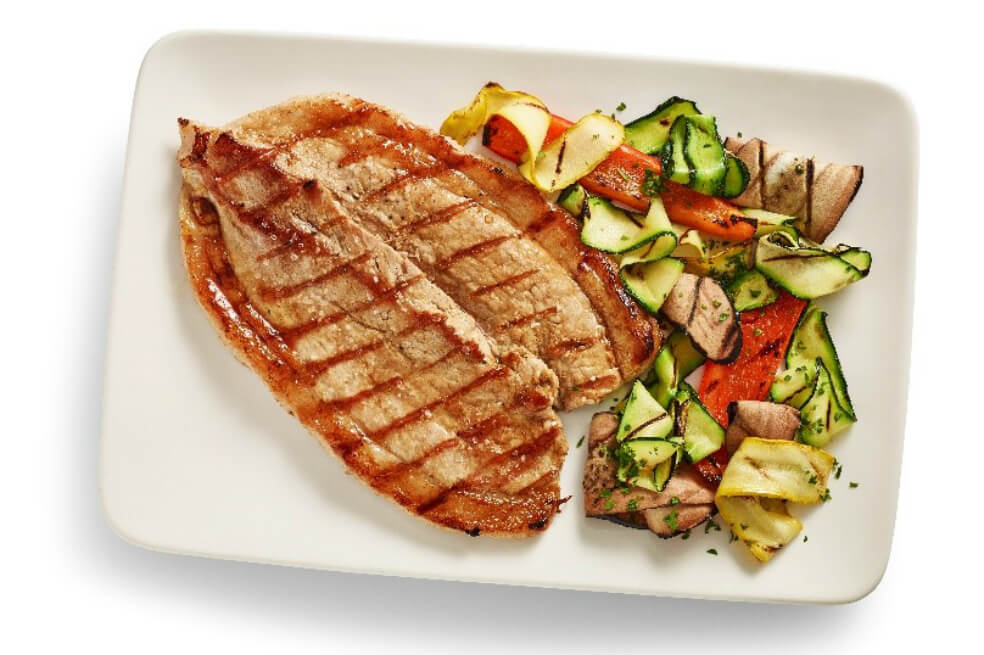 ¿Cómo preparar una punta de anca de cerdo a la parrilla con vegetales asados?
