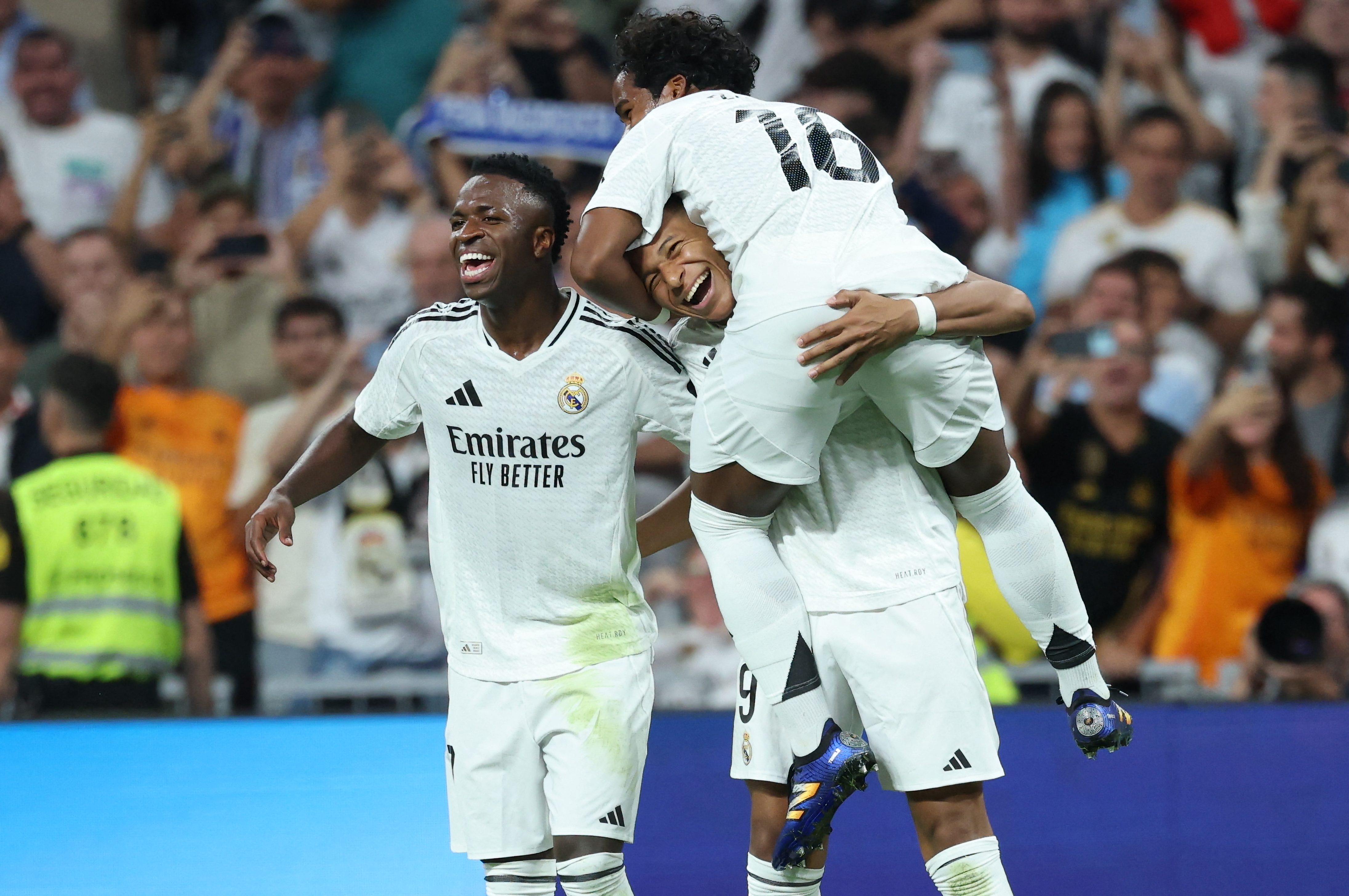 Real Madrid's French forward #09 Kylian Mbappe (C) celebrates with Real Madrid's Brazilian forward #16 Endrick (TOP) and Real Madrid's Brazilian forward #07 Vinicius Junior after scoring his team's fourth goal from the penalty spot during the Spanish league football match between Real Madrid CF and RCD Espanyol at the Santiago Bernabeu stadium in Madrid, on September 21, 2024.