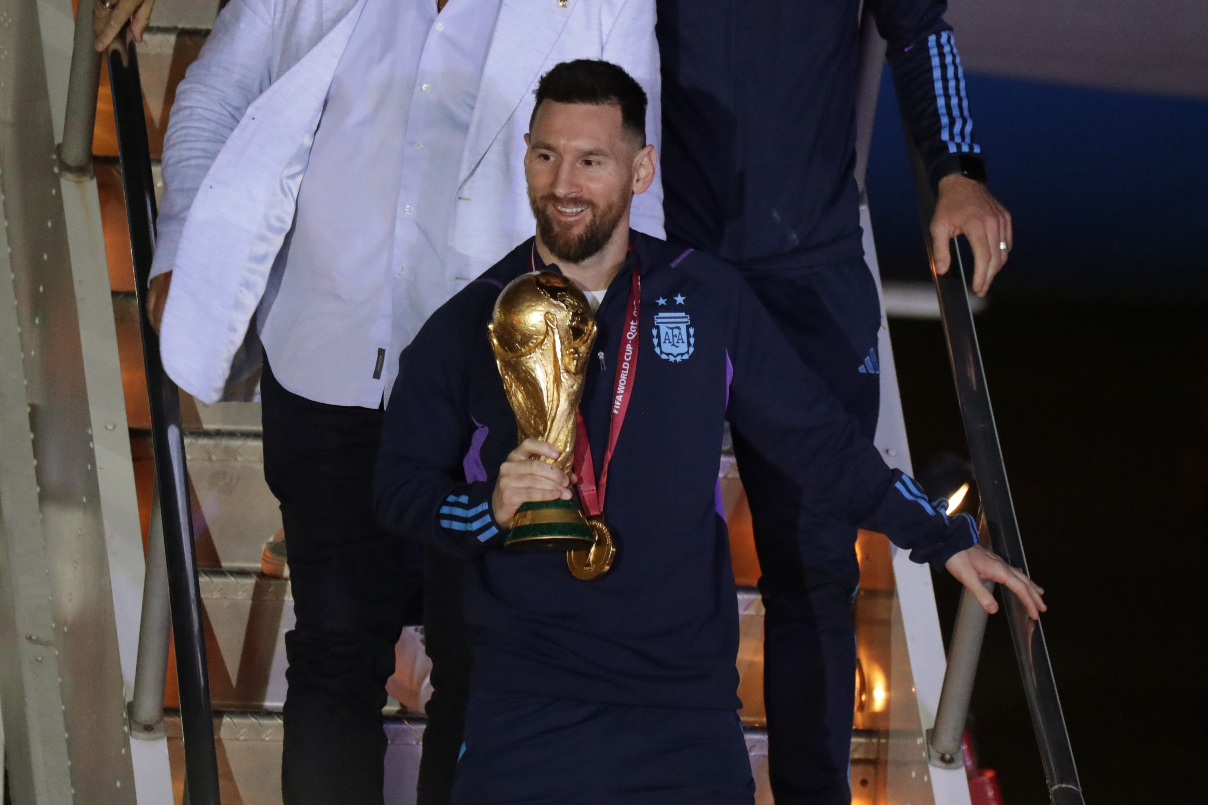 AMDEP9828. EZEIZA (ARGENTINA), 19/12/2022.- Lionel Messi de la selección argentina de fútbol desciende con el trofeo del Mundial de Fútbol Qatar 2022 a su llegada hoy, al Aeropuerto Internacional de Ezeiza a unos 22km de Buenos Aires (Argentina). EFE/ Raúl Martínez