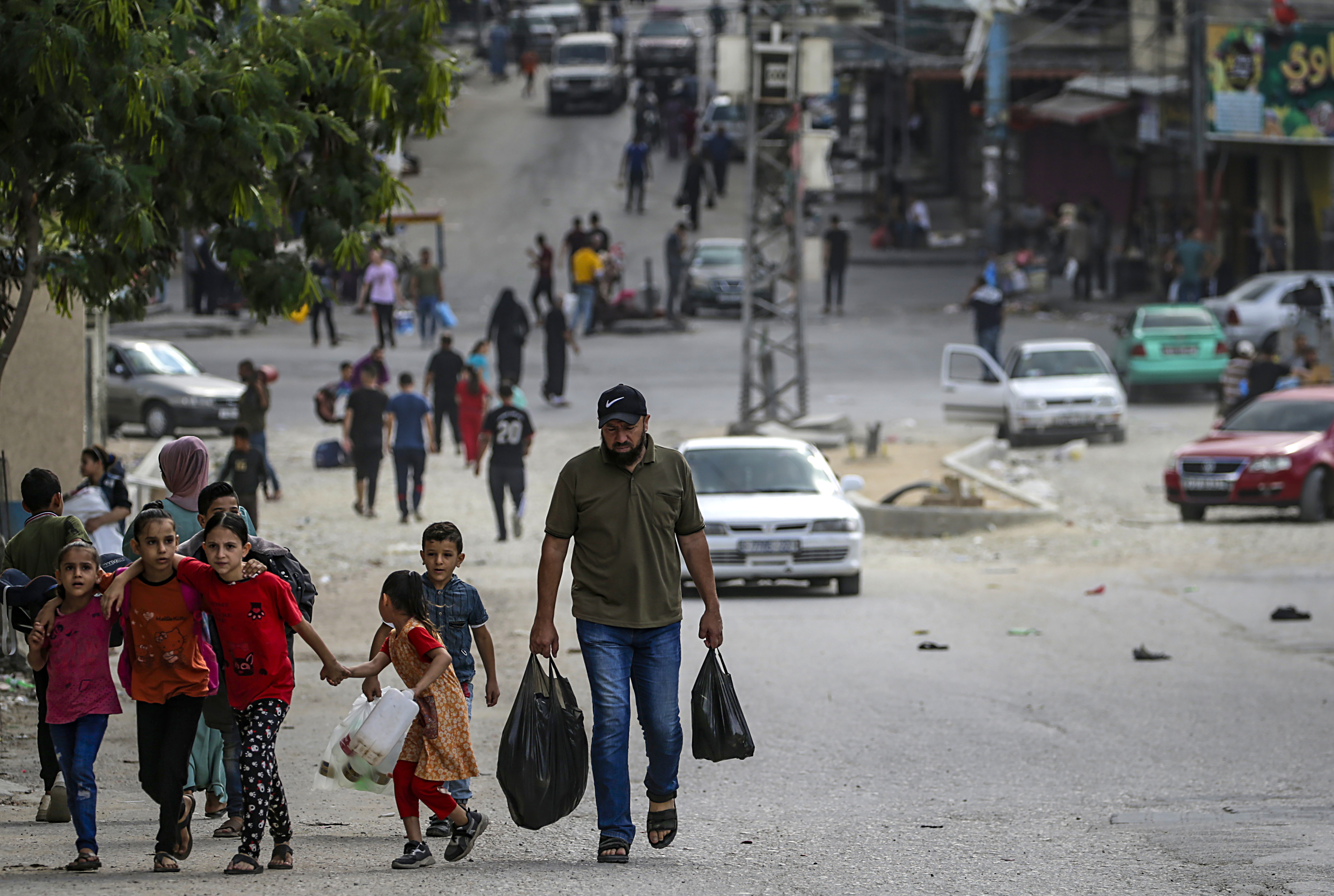 Gaza (---), 16/10/2023.- A Palestinian carrying food walks with his children in Al Shejaeiya neighbourhood, east of Gaza City, 16 October 2023. Israel has warned all citizens of the Gaza Strip to move to the south ahead of an expected invasion. More than 2,750 Palestinians and 1,400 Israelis have been killed according to the Israel Defense Forces (IDF) and Palestinian Health Ministry after Hamas militants launched an attack against Israel from the Gaza Strip on 07 October. EFE/EPA/MOHAMMED SABER