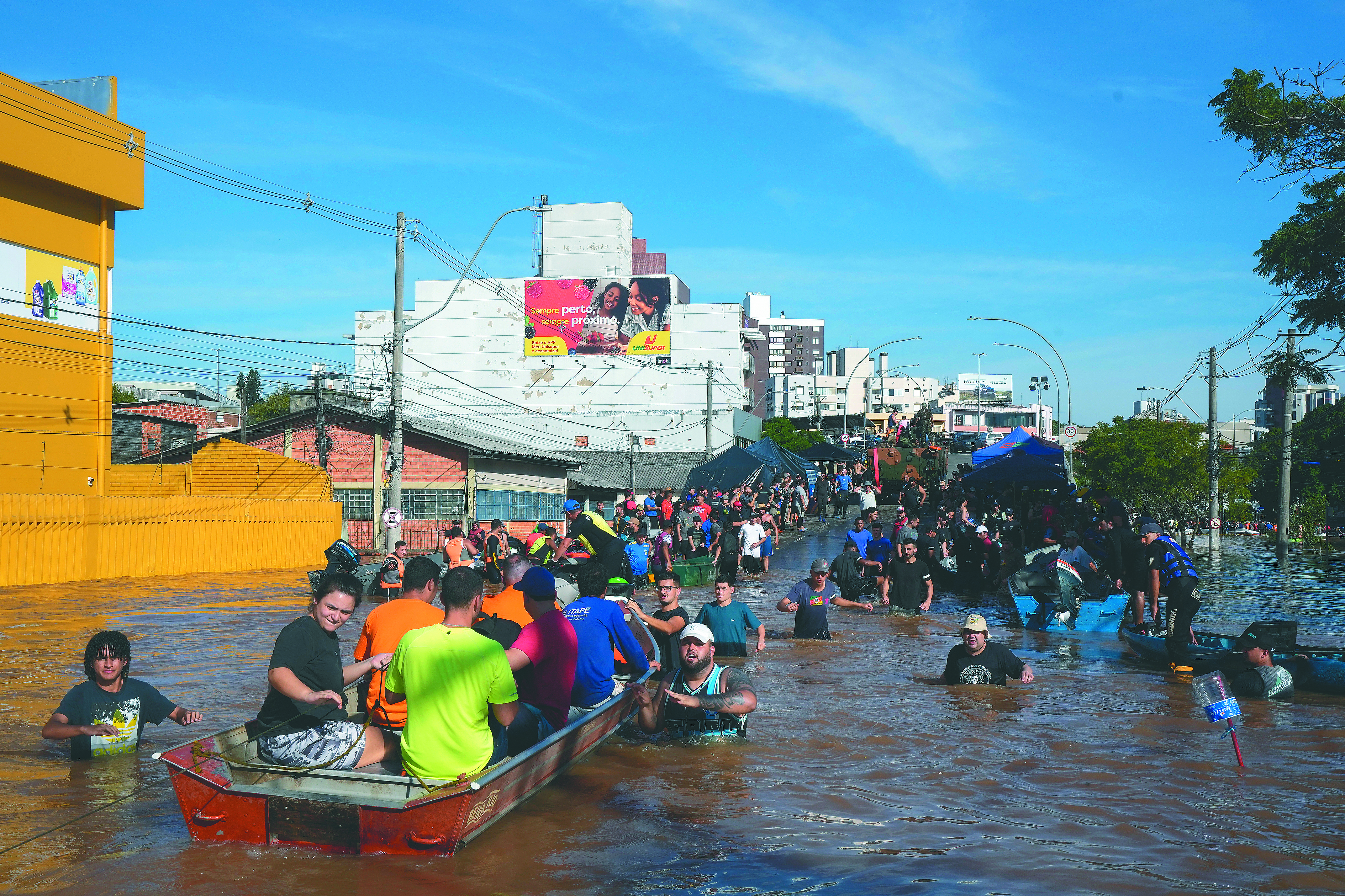 Voluntarios ayudan a los residentes a evacuar un área inundada por fuertes lluvias, en Porto Alegre.