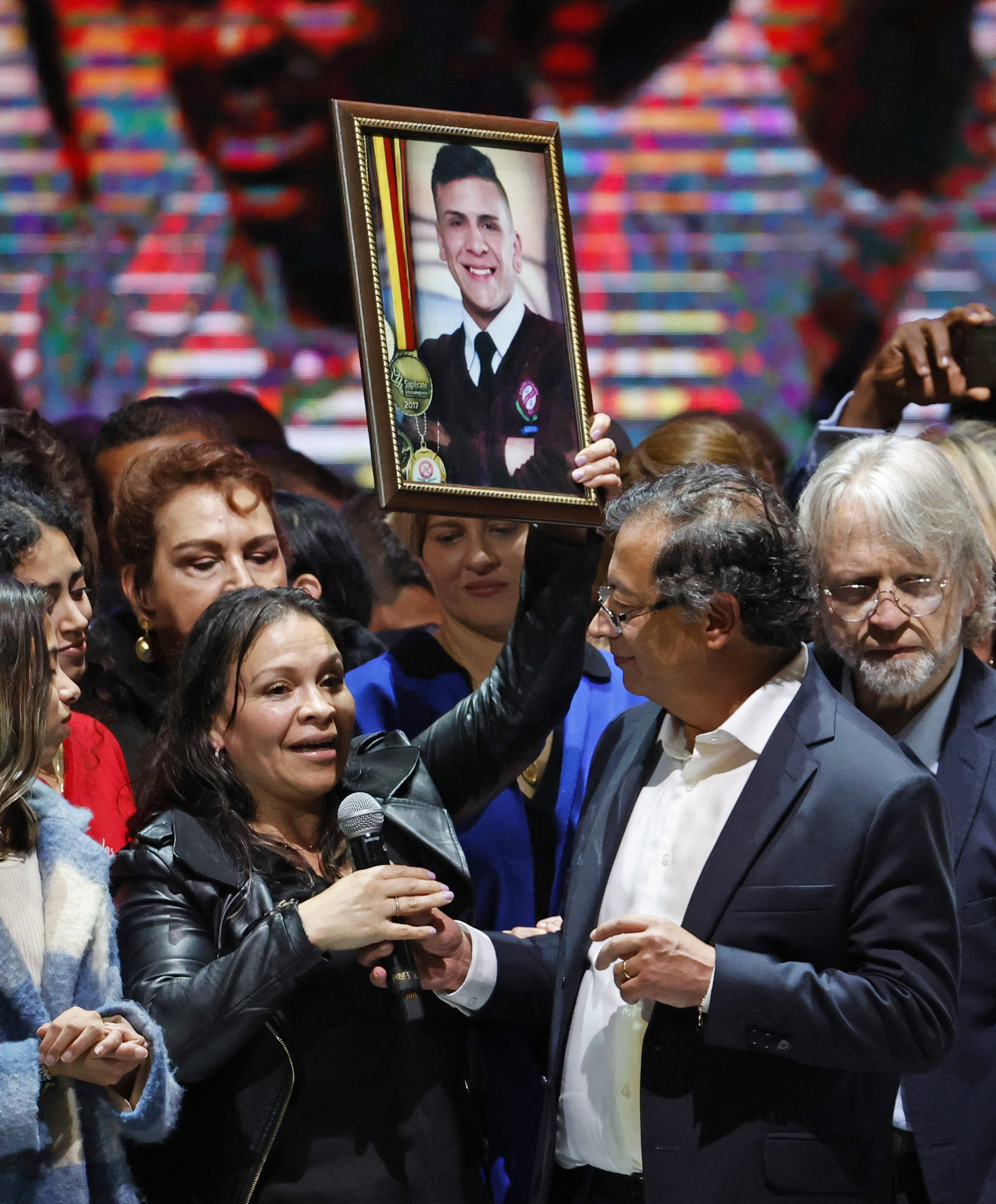 AME7774. BOGOTÁ (COLOMBIA), 19/06/2022.- El presidente electo Gustavo Petro le cede el micrófono a Jenny Alejandra Medina, madre de Dylan Cruz, uno de los jóvenes asesinados por el Escuadrón Móvil Antidisturbios (Esmad) durante las protestas del 2018, quien habla durante la celebración tras obtener 11.270.944 votos, equivalentes al 50,49 %,  hoy en el Movistar Arena en Bogotá (Colombia). El presidente electo de Colombia, el izquierdista Gustavo Petro, propuso este domingo que los países de América Latina se unan para hablar con Estados Unidos y sentar las bases de una "transición energética" ante los estragos causados por el cambio climático, mientras que la vicepresidenta electa de Colombia, Francia Márquez, primera mujer afrodescendiente que ocupará el cargo, celebró este domingo que el país tendrá el primer "gobierno popular y de los nadies" de su historia, "un paso importante para reconciliar la nación". EFE/ Mauricio Dueñas Castaneda