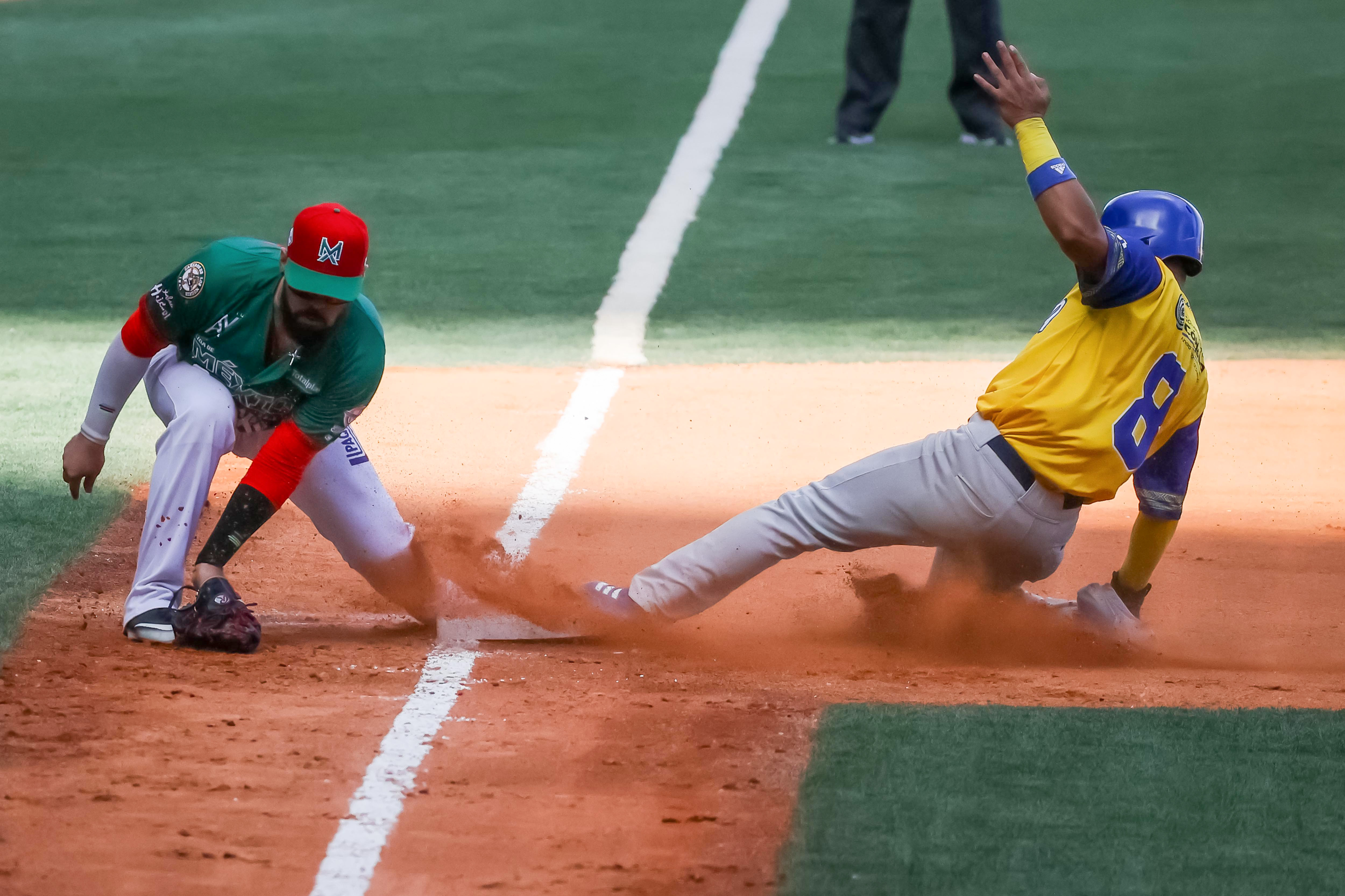 CARACAS (VENEZUELA), 10/02/2023.- Orlando Pina (i) de Cañeros de Mochis atrapa una pelota en tercera base frente Fabián Pertuz de los Vaqueros de Montería de Colombia hoy, en el partido por el tercer lugar de la Serie del Caribe 2023 en el estadio Monumental de Caracas Simón Bolívar en Caracas (Venezuela). EFE/ Miguel Gutiérrez